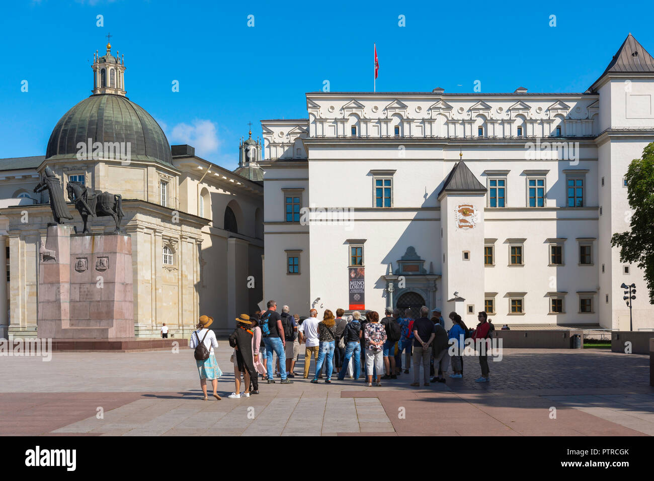 Turismo turisti in Europa, un gruppo di tour sorge in piazza della cattedrale a Vilnius su una mattina d'estate guardando il palazzo dei Granduchi di Lituania. Foto Stock