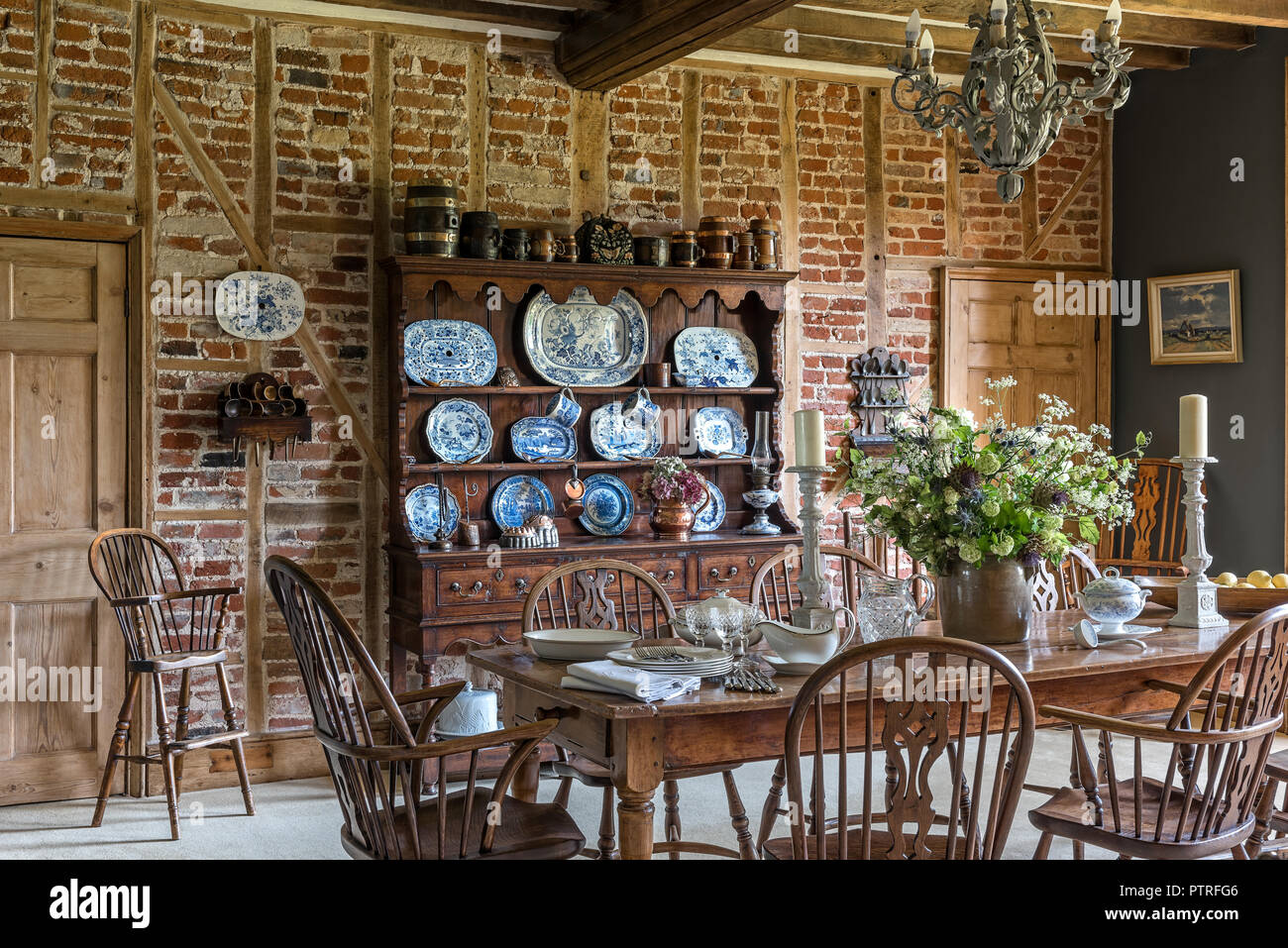 Porcellane decorative su antichi comò in legno con tavolo e sedie nel restaurato del XVI secolo agriturismo Foto Stock