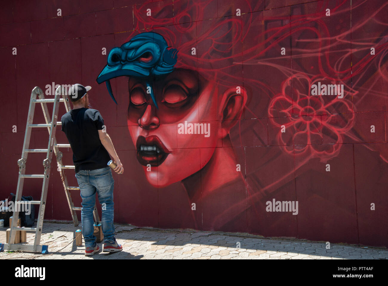 Johannesburg, Sud Africa, 10 ottobre, 2018. "Rekso' funziona sul suo murale come l'annuale "Città d'Oro" Arte Urbana Festival ha dato dei calci a fuori i suoi graffiti street tour a Johannesburg oggi. Etichettati atti di vandalismo da parte di alcuni, il festival mette in luce gli aspetti positivi di questa forma d'arte e mira ad aumentare l'apprezzamento per esso tra il pubblico in generale. Questi progetti murale spesso consentono di migliorare e attivare i siti in Johannesburg area urbana che sono o dimenticata o temuto dagli abitanti della città, hanno detto gli organizzatori. Credito: Eva-Lotta Jansson/Alamy Live News Foto Stock