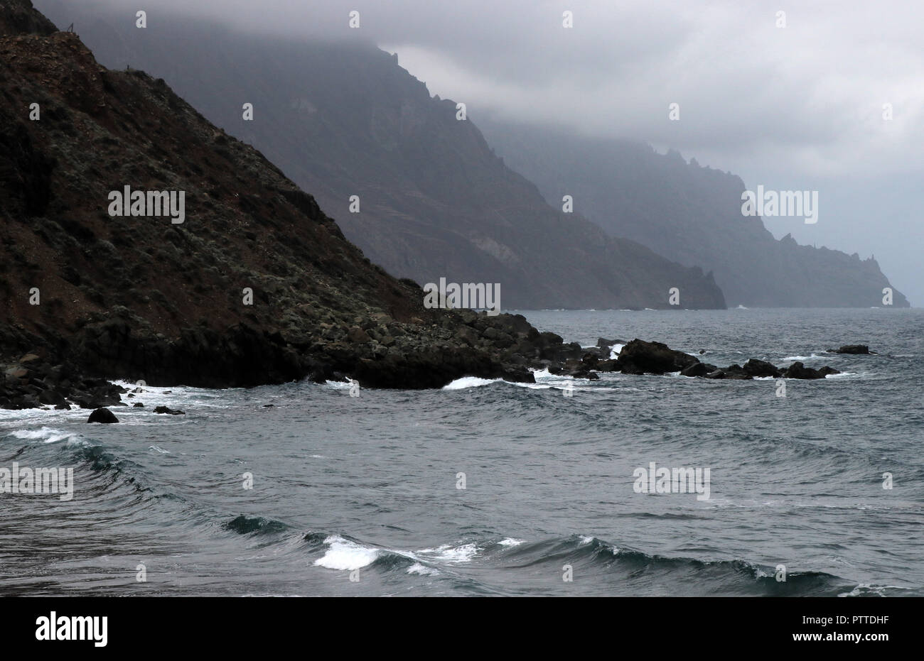 Wild sezione sbriciolato della scogliera a Playa del Roque de las Bodegas vicino Taganana nel nord dell'isola delle Canarie di Tenerife il 24.09.2018. Nuvole basse, imprevedibile onde con forti correnti - qui si bagnano relativamente indisturbato, ma a vostro rischio e pericolo. | Utilizzo di tutto il mondo Foto Stock