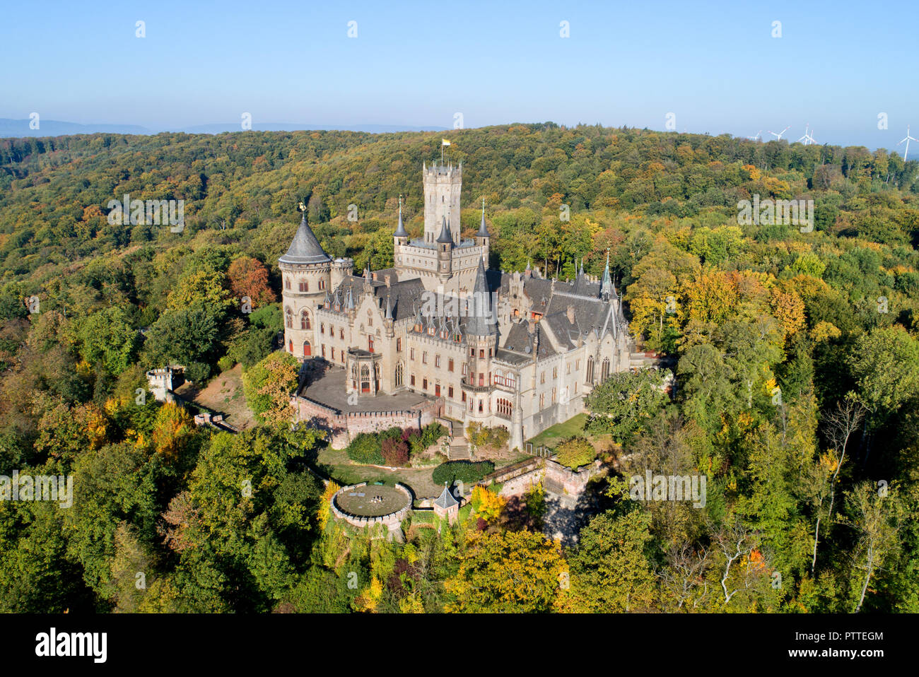 Pattensen, Bassa Sassonia. Undicesimo oct, 2018. Il Castello di Marienburg si erge nella luce del sole di mattina in mezzo autunnali alberi scoloriti (fotografia aerea con drone). Re Giorgio V di Hannover ha avuto il neo-gotico residence costruito tra il 1858 e il 1869. 150 anni più tardi il castello è di proprietà privata da Ernst August principe di Hannover Jr e una popolare meta escursionistica nella regione di Hannover. Credito: Julian Stratenschulte/dpa/Alamy Live News Foto Stock