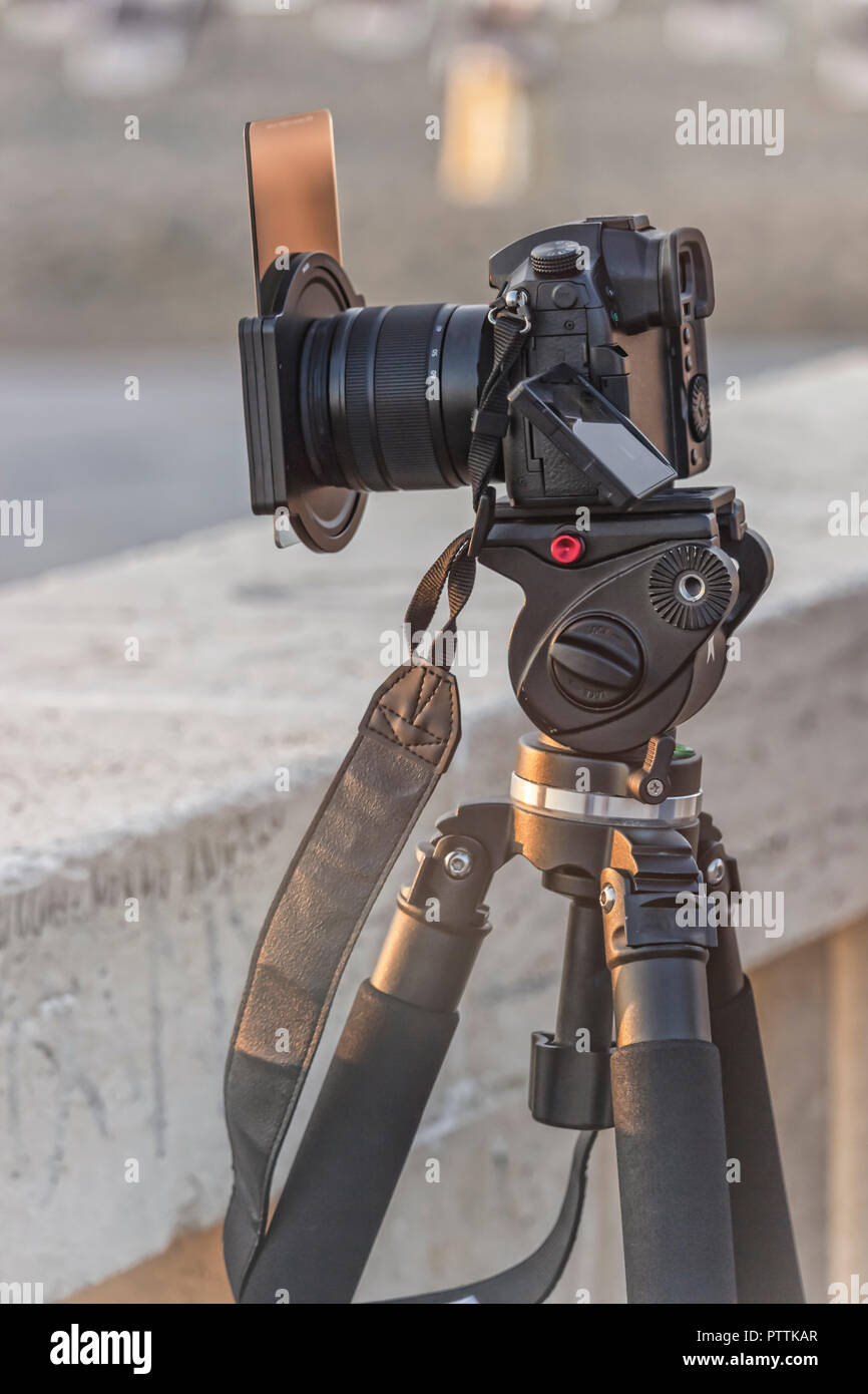 Fotocamera reflex digitale pov, su un treppiede fotografare il tramonto con ND (Neutral Density ) filtro sulla lente Foto Stock