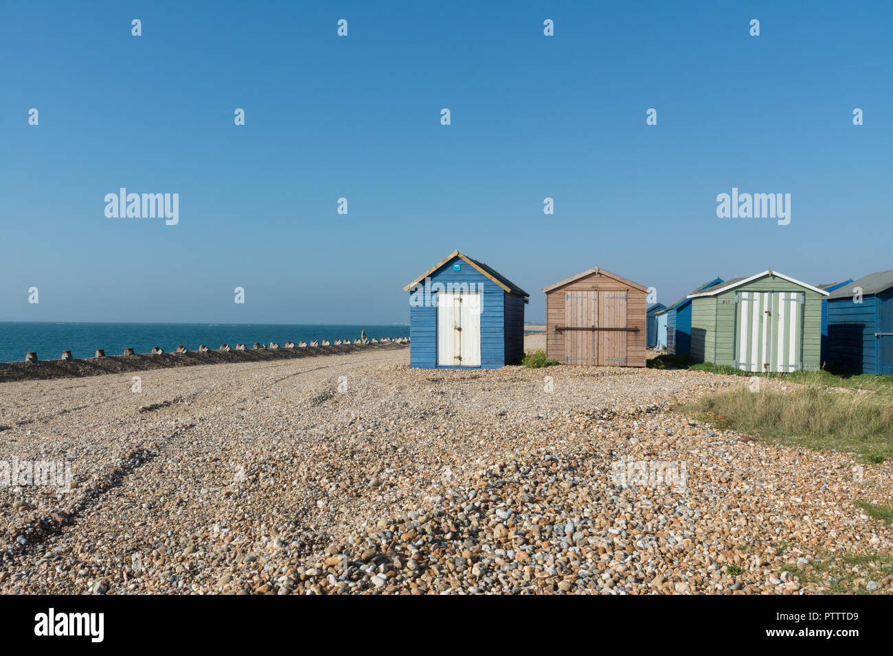 Capanne sulla spiaggia in riva al mare sulla spiaggia di ciottoli a Hayling Island, Hampshire, Regno Unito Foto Stock