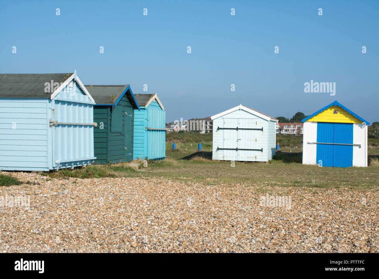 Pittoresca spiaggia di capanne sulla spiaggia di ciottoli a Hayling Island, Hampshire, Regno Unito, in una giornata di sole Foto Stock