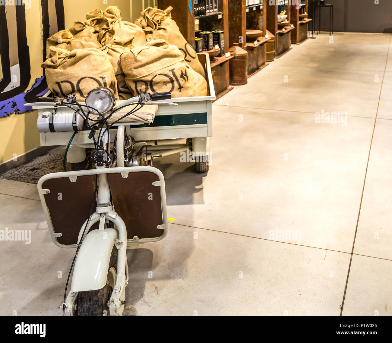 BOLOGNA, Italia - 2 ottobre 2018: luci sono illuminanti vecchio scooter con sacchi di juta al fico EATALY mondo, la più grande industria agro-alimentare parco nel mondo Foto Stock