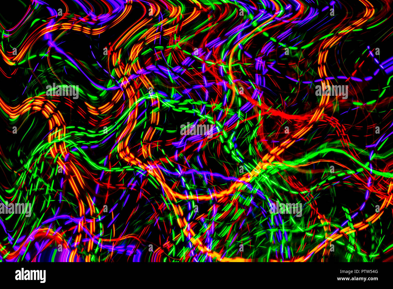 La caotica di linee di luci di colore su sfondo scuro. Luci colorate si sposta in uno spazio nero. Foto Stock