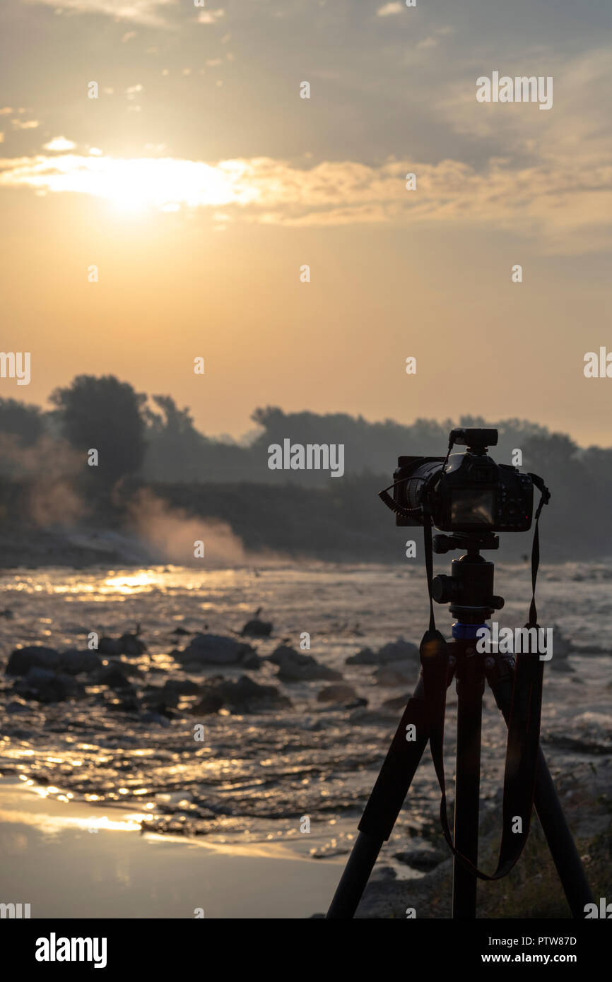 La fotocamera su un treppiede di scatto a sunrise Foto Stock