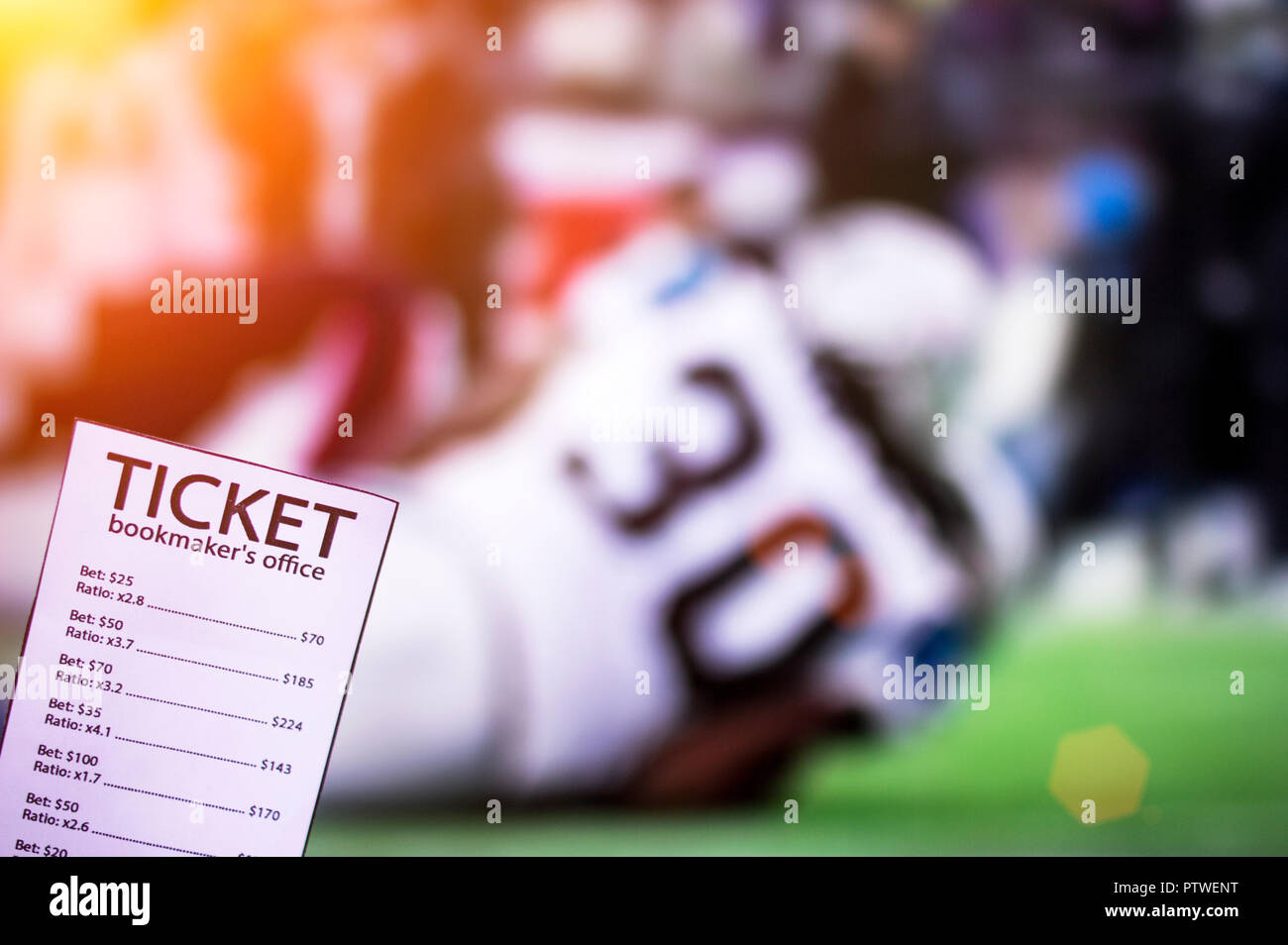 Bookmaker il biglietto, contro lo sfondo della TV su cui il football americano sta andando, scommesse sportive, play Foto Stock