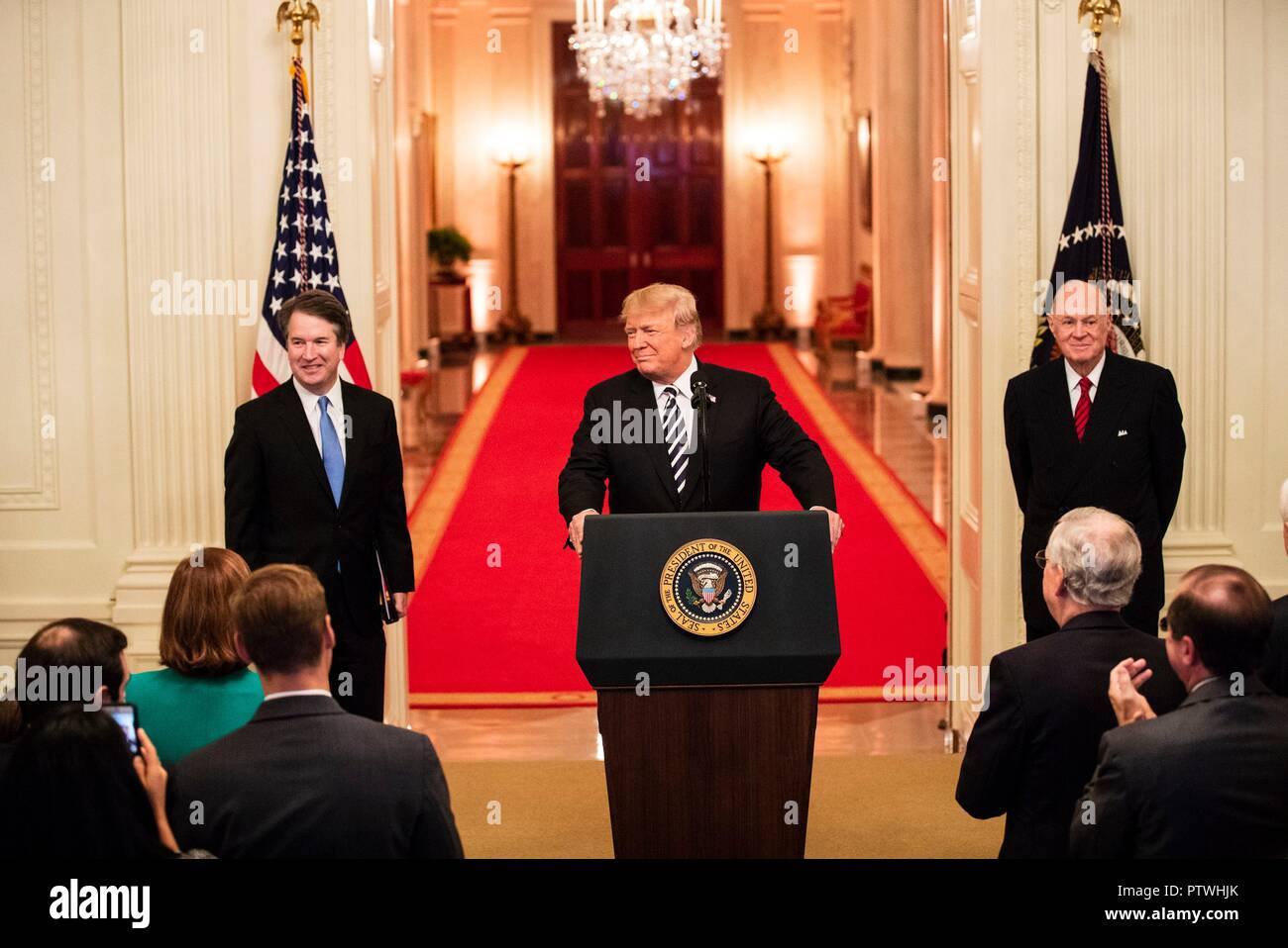 U.S presidente Donald Trump risolve il pubblico come pensionati della Corte Suprema Anthony Kennedy, destra e giudice Brett Kavanaugh, sinistra, guardare a seguito di un pubblico simbolico giuramento alla Casa Bianca il 8 ottobre 2018 a Washington DC. Foto Stock