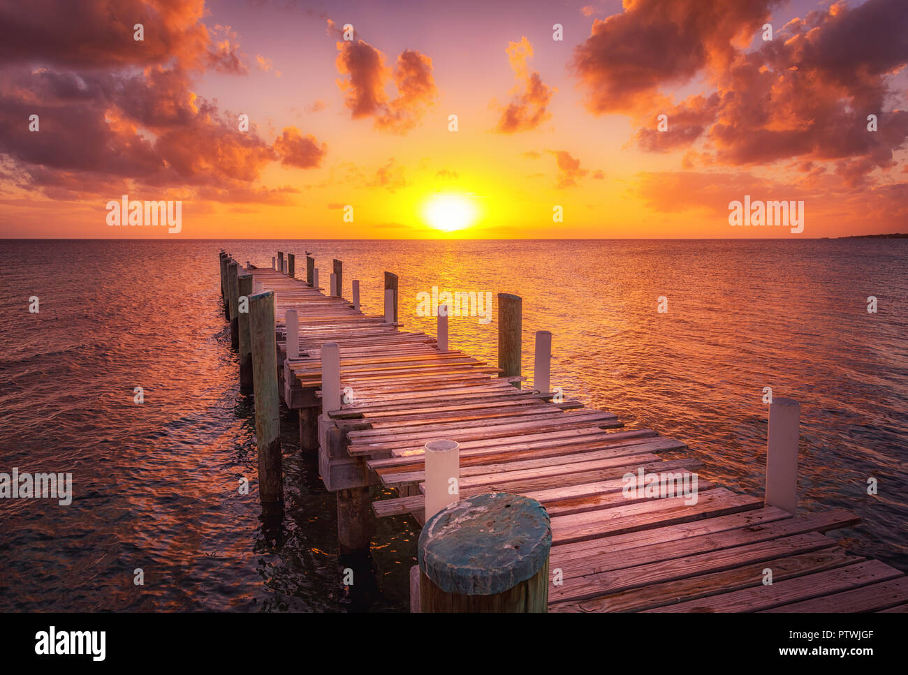 Dock durante il tramonto dei caraibi, bellissimi colori magenta e la prospettiva di questo dock in barca e pesca in dock Eleuthera Island, Bahamas Foto Stock