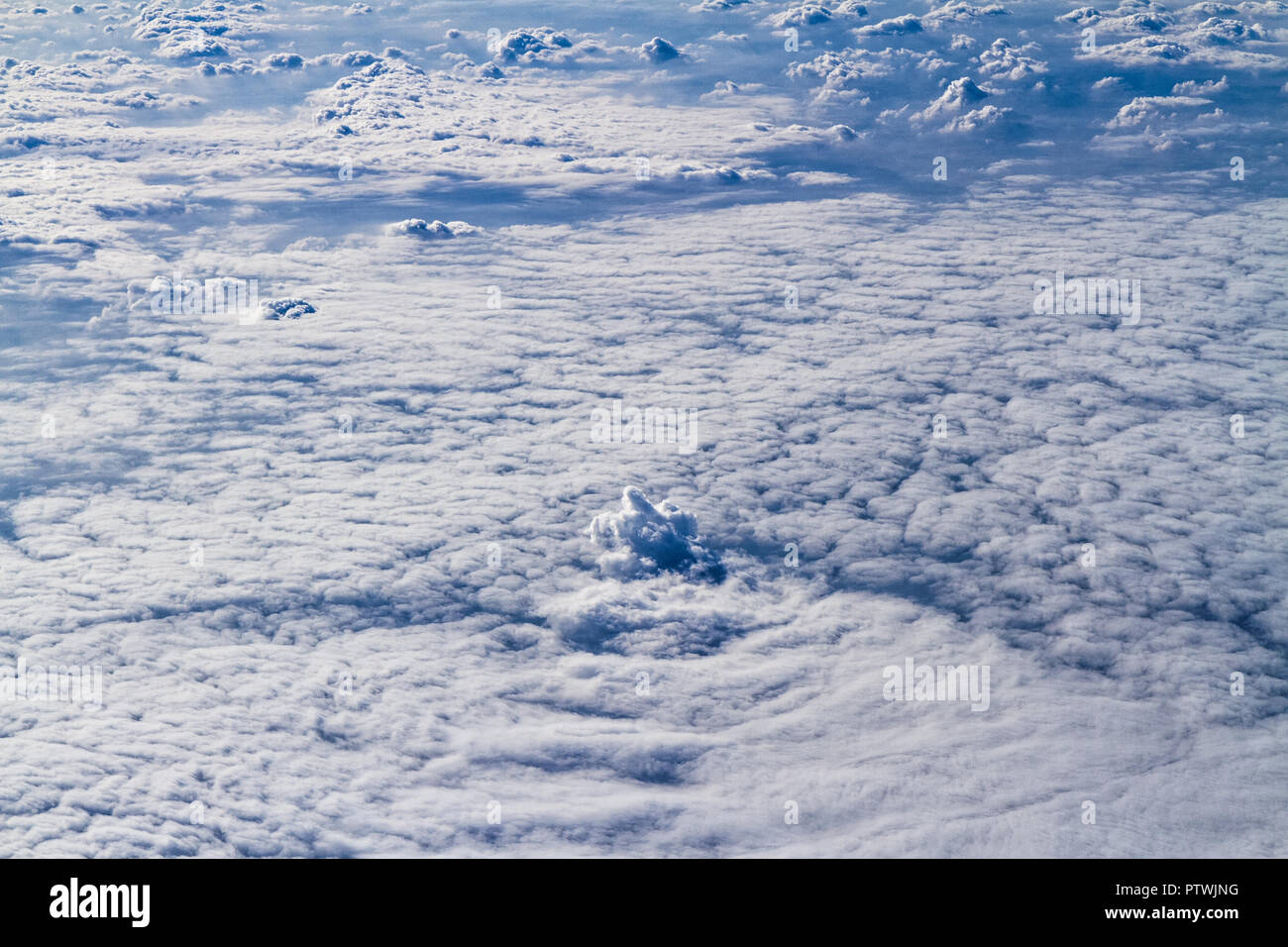 Vista aerea di corpi unici di cumulus temporale nuvole visto attraverso una finestra di aeroplano Foto Stock