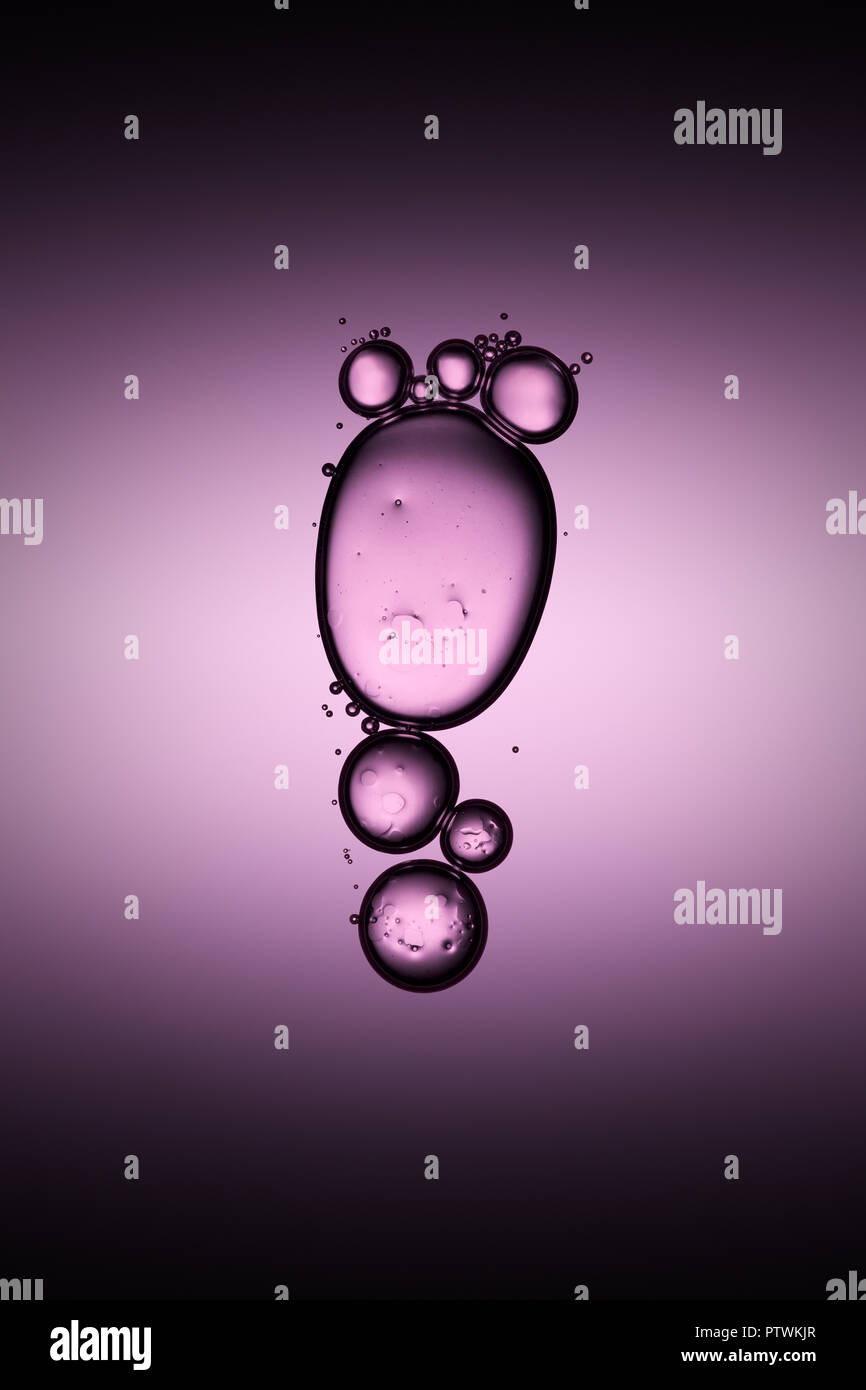 Bolle trasparenti galleggiante nel liquido, sfondo viola Foto Stock