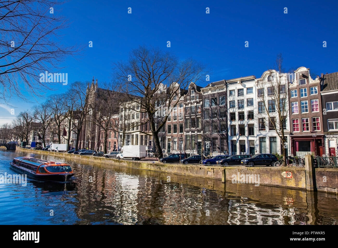 Imbarcazione turistica touring attorno a canali di Amsterdam Foto Stock
