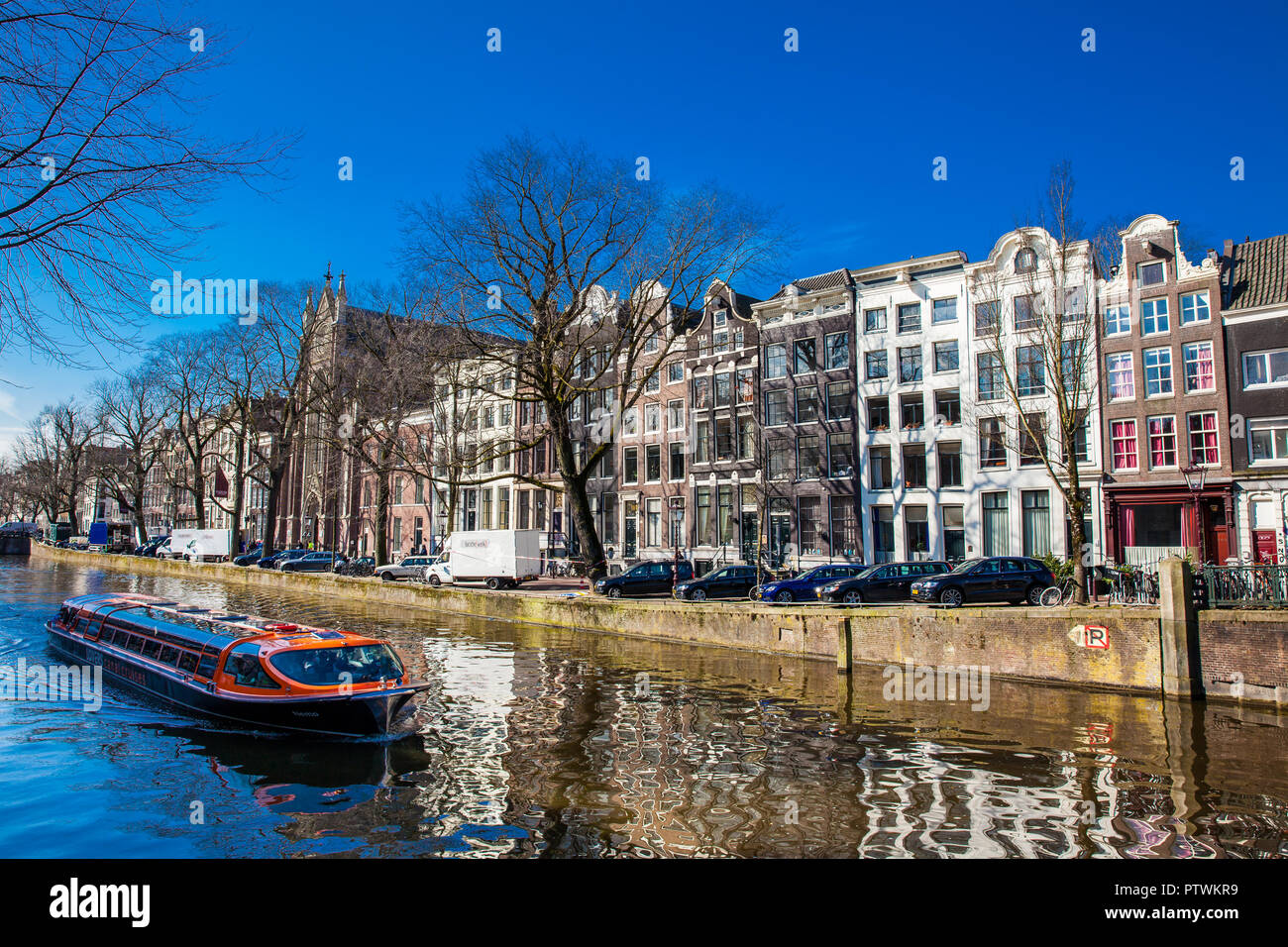 Imbarcazione turistica touring attorno a canali di Amsterdam Foto Stock