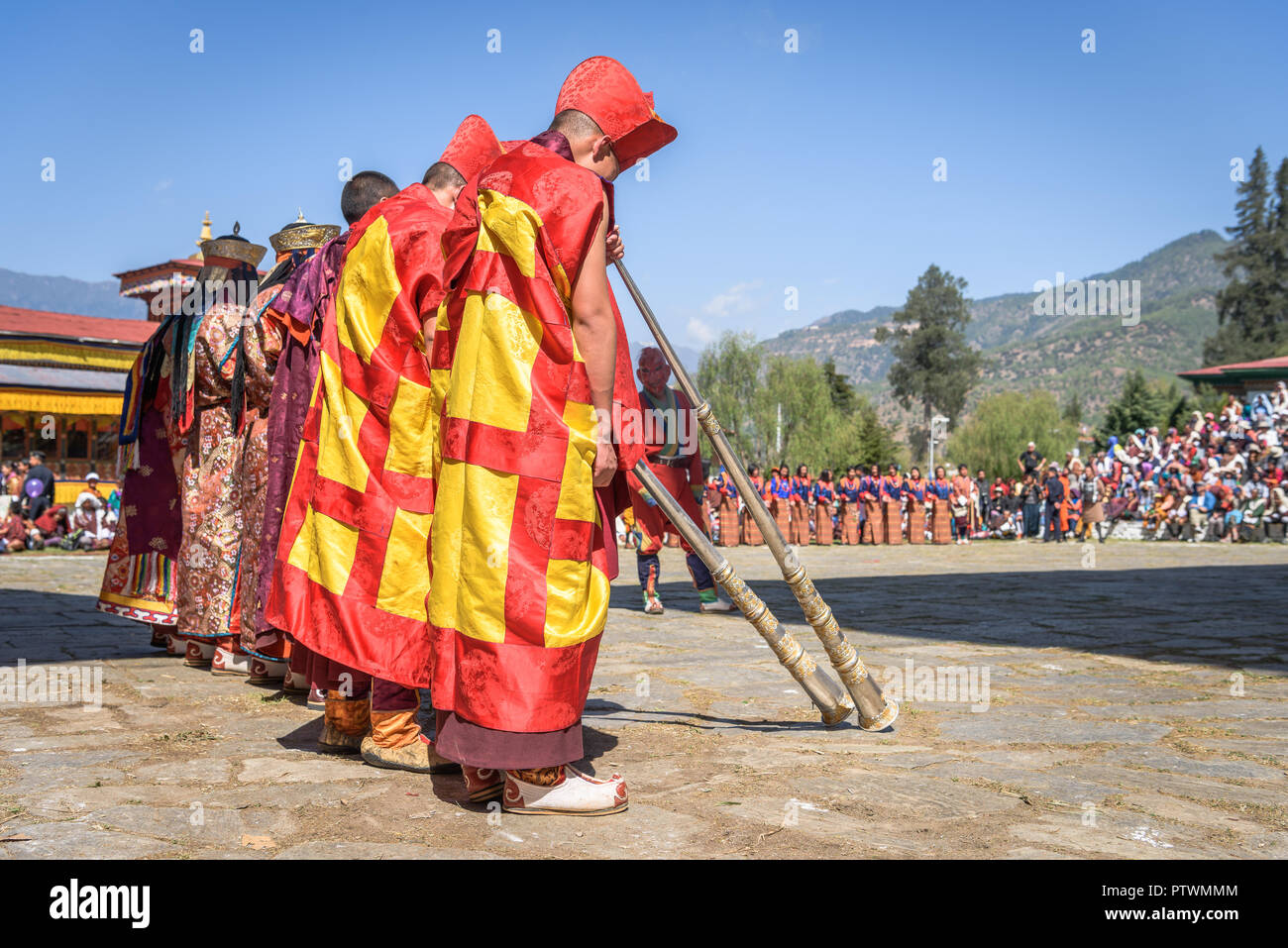 I monaci a fare musica con le trombe per colorata mask dance annuale di Paro Tsechu festival in Bhutan Foto Stock