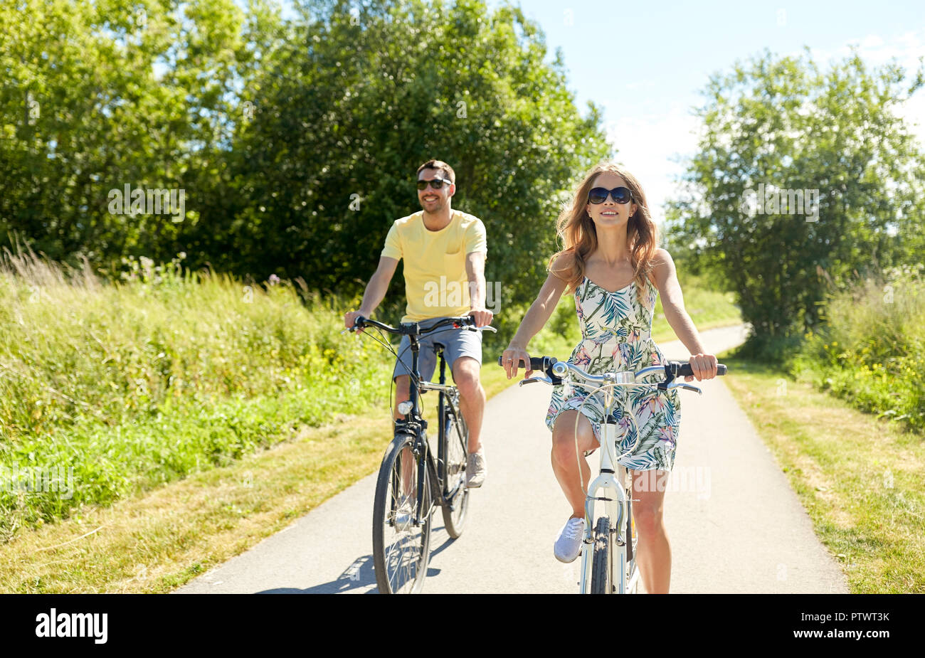 Felice coppia giovane equitazione biciclette in estate Foto Stock