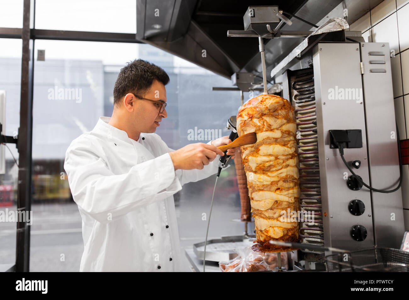 Chef per affettare la carne di Döner da spit a kebab shop Foto Stock