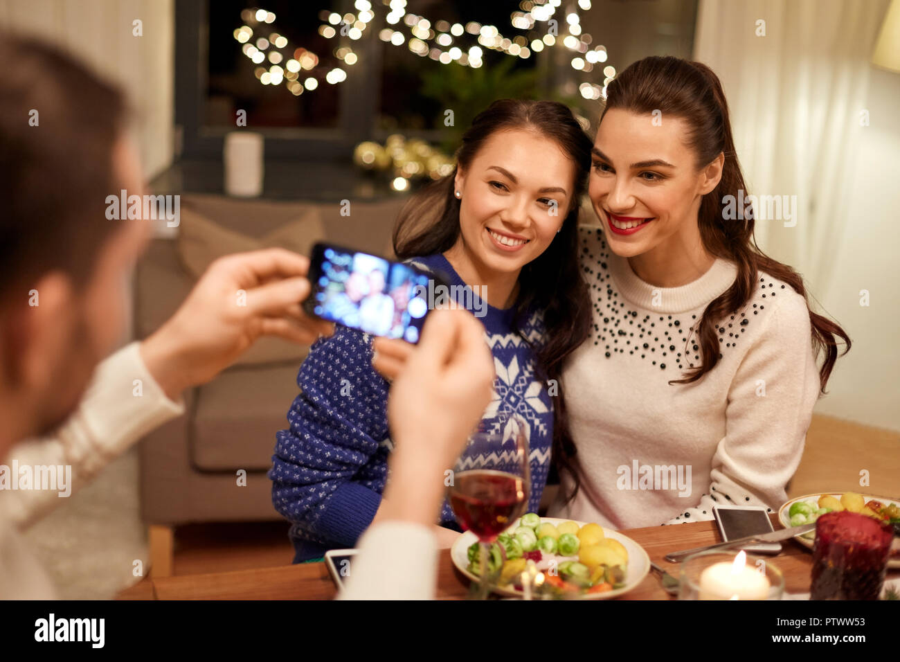 Amici avente la cena di natale e di scattare una foto Foto Stock