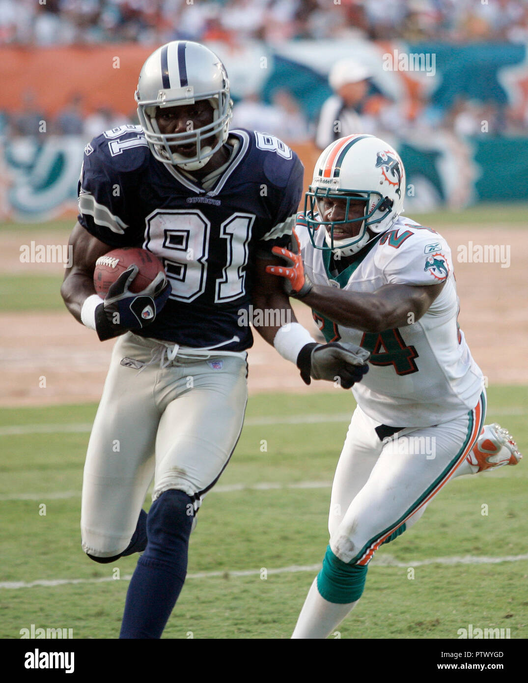 Dallas Cowboys wide receiver Terrell Owens è spinto fuori dei limiti dopo il prelievo di un primo verso il basso dai delfini di Miami la sicurezza Reynaldo Hill nel quarto trimestre NFL azione al Dolphin Stadium di Miami il 16 settembre 2007. Foto Stock