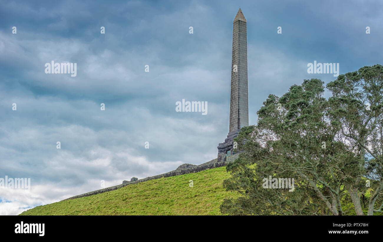 Obelisco sulla cima di una collina dell'albero ad Auckland contro un cielo grigio con le nuvole Foto Stock