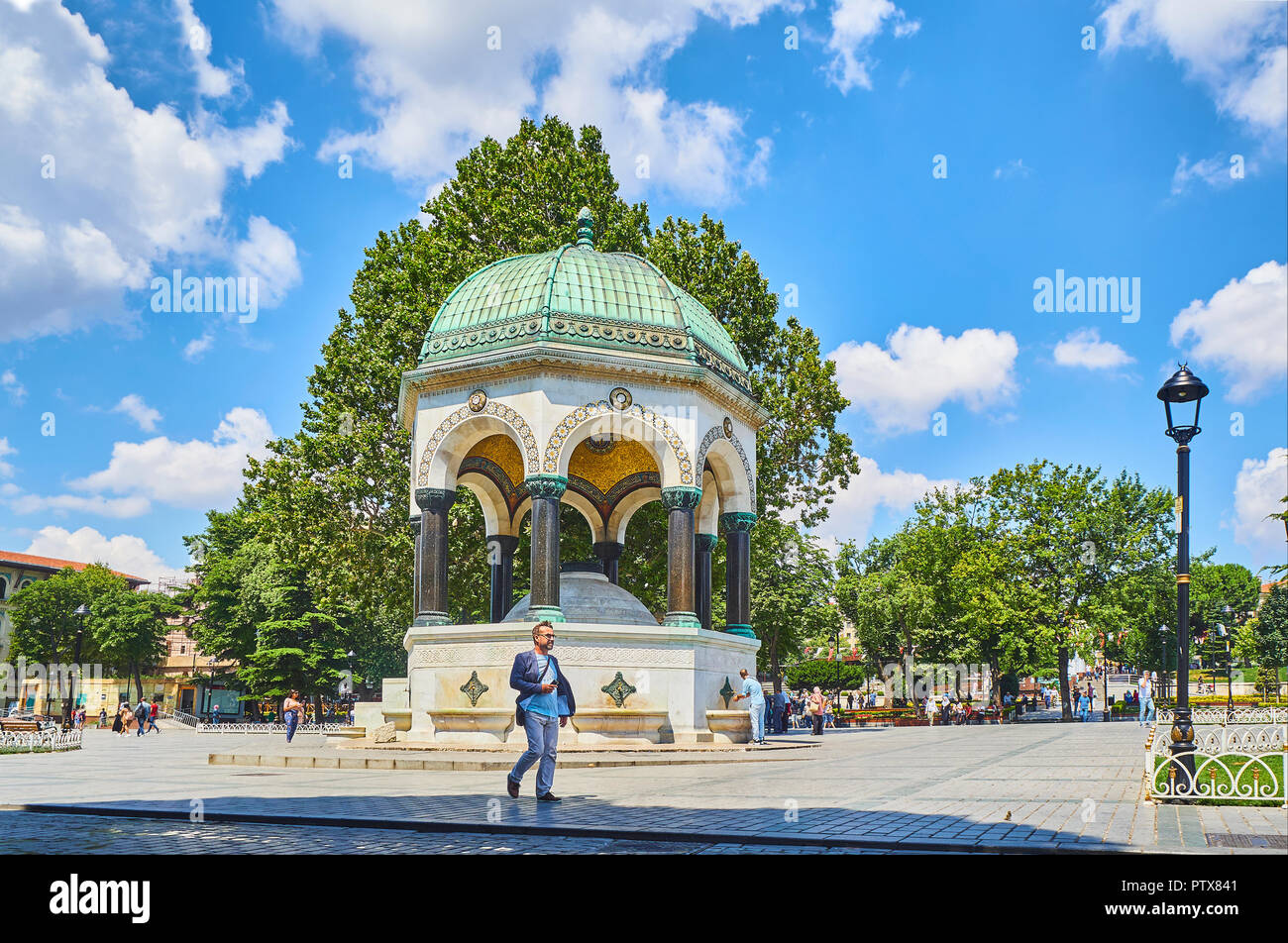 Un cittadino a piedi nella parte anteriore del tedesco della Fontana e il lato nord dell'Ippodromo di Costantinopoli, Sultan Ahmet Square. Istanbul, Turchia. Foto Stock