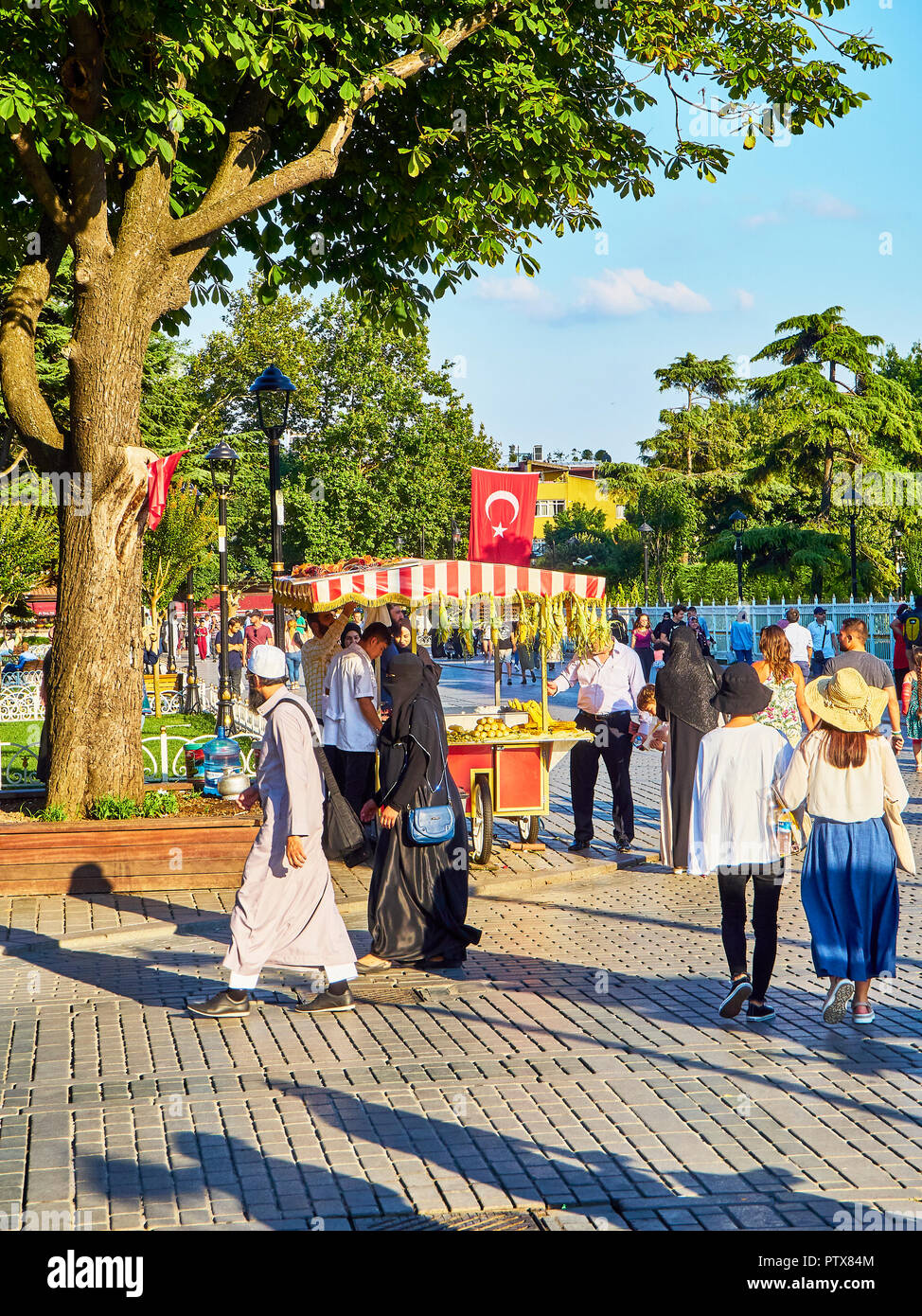 Istanbul, Turchia - 8 luglio 2018. I cittadini a piedi vicino ad un le pannocchie di granoturco stallo nella zona di Sultanahmet Park. Istanbul, Turchia. Foto Stock