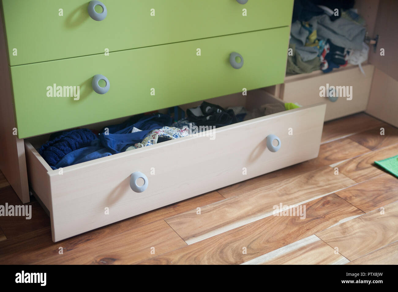 Aprire il cassetto pieno di vestiti in una camera da letto per bambini Foto Stock