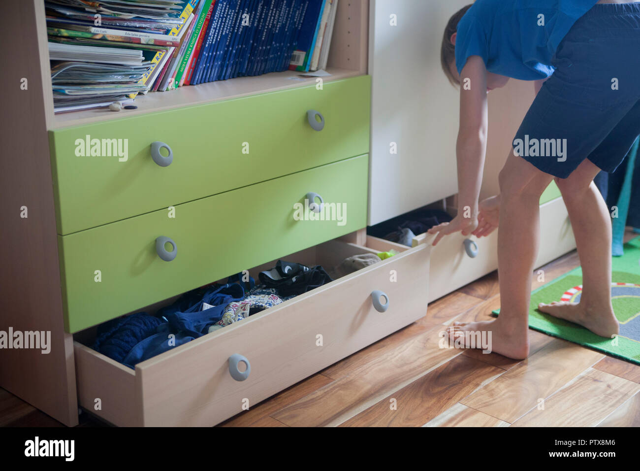 Aprire il cassetto pieno di vestiti in una camera da letto per bambini Foto Stock