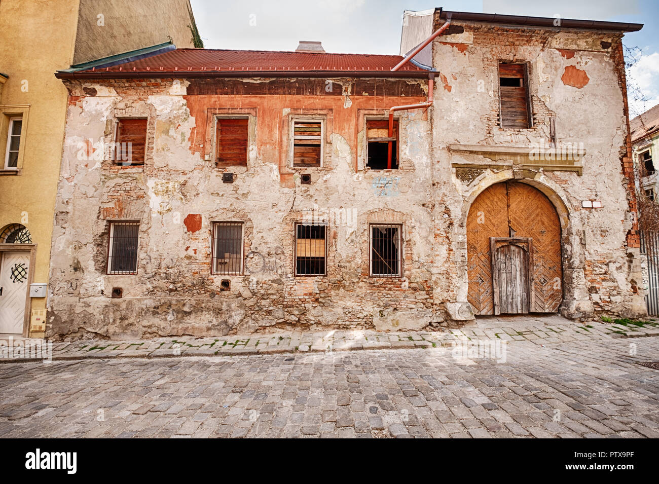 Si tratta di un vecchio edificio con una grande porta di legno ingresso che è nel bisogno di riparazioni sorge accanto ad una strada di ciottoli nella Città Vecchia (Staré Mesto) di Foto Stock