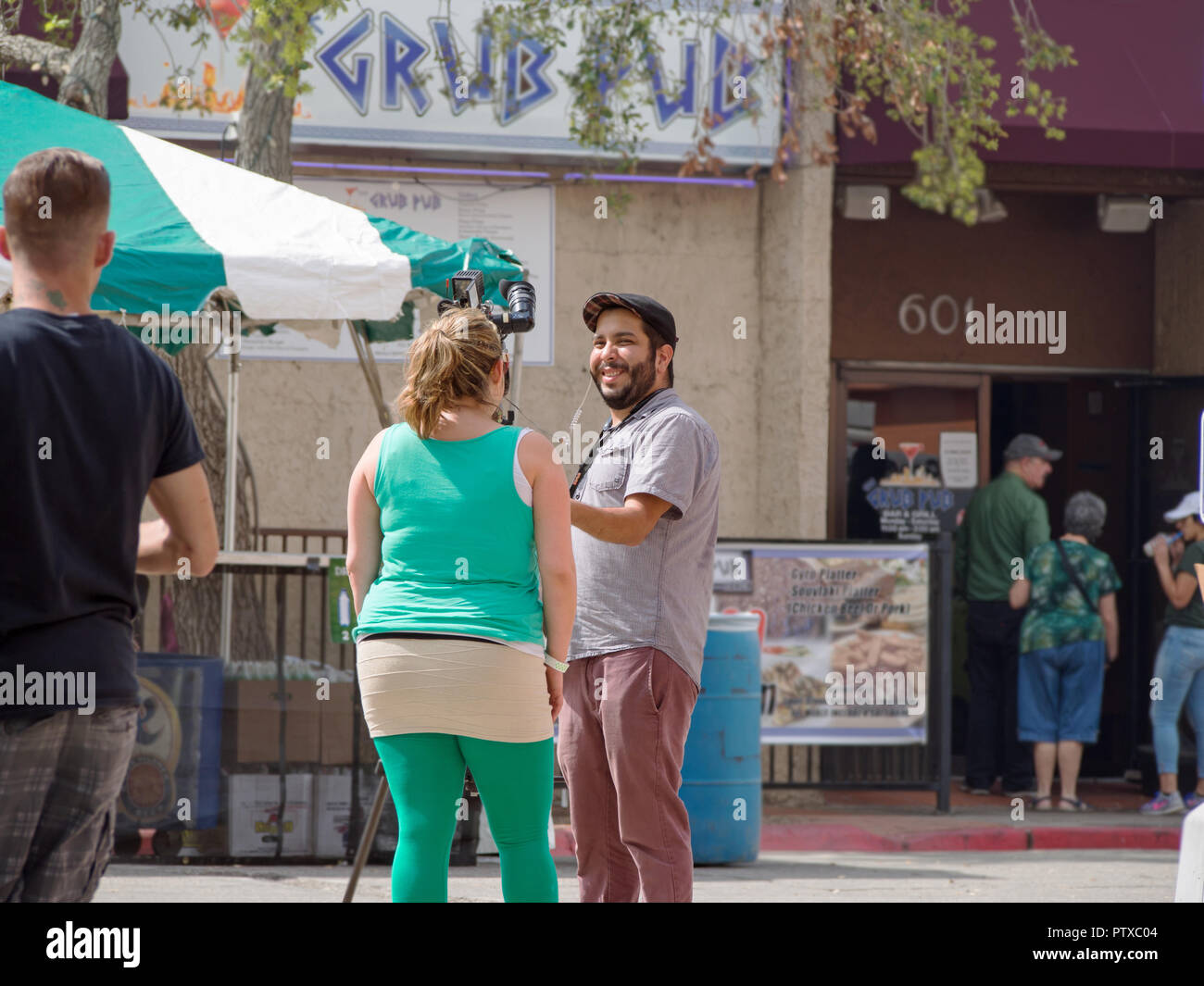 Un fotoreporter a parlare con una donna al San Patrizio blocco Festival.Questo evento annuale è trattenuto nel Corpus Christi, Texas USA. Foto Stock