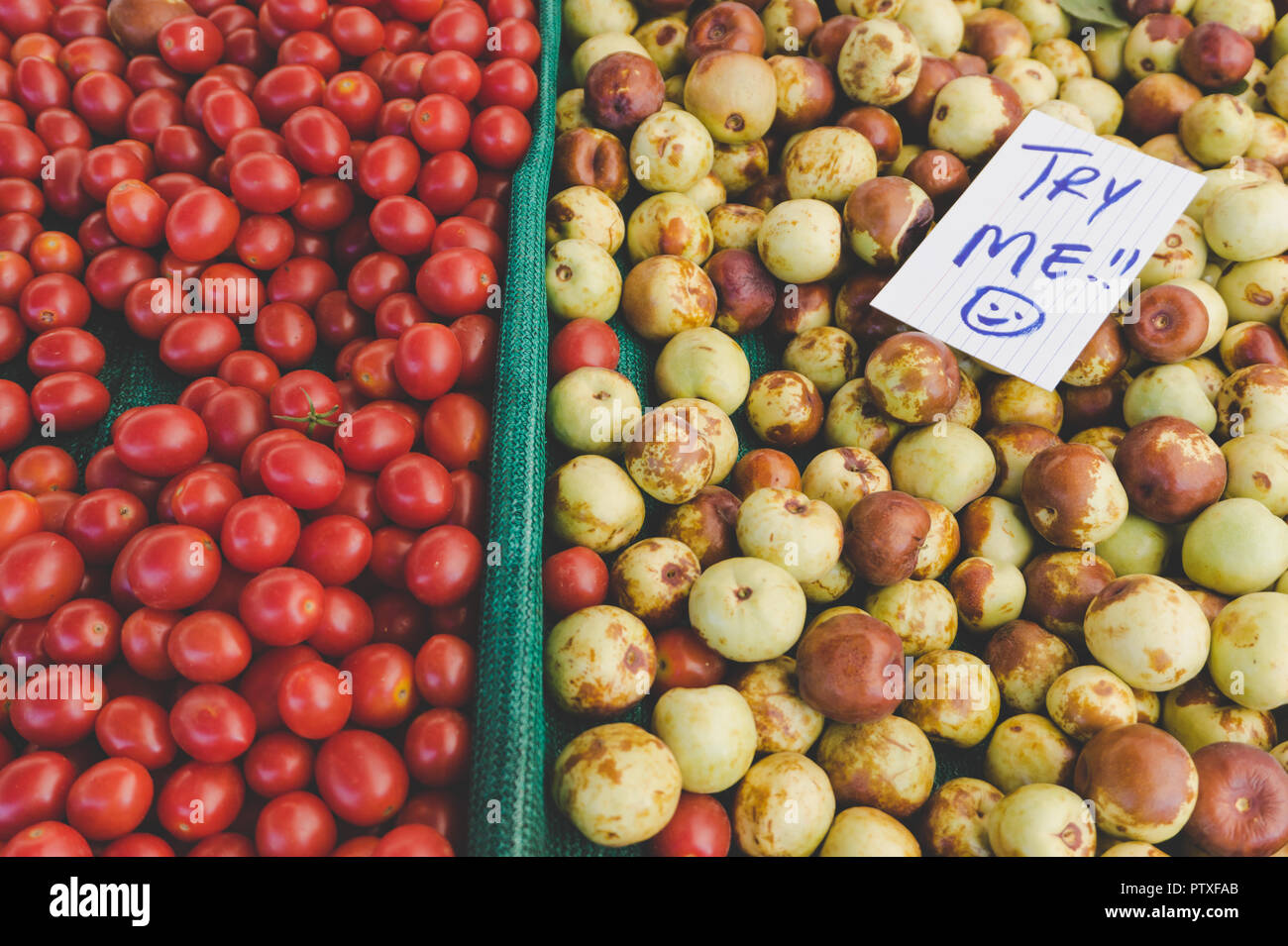 Visualizzazione delle succose pomodori rossi e qualche altro organico a base di frutta o verdura con un cartello che dice "Try me": mercato agricolo nel sud della California Foto Stock