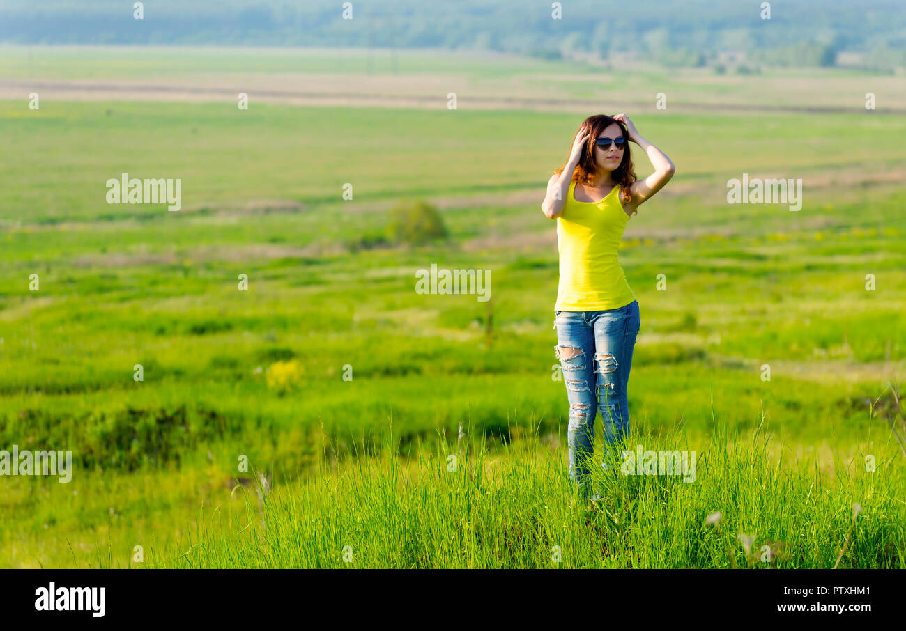 Donna in occhiali da sole guarda nella distanza all'aperto Foto Stock