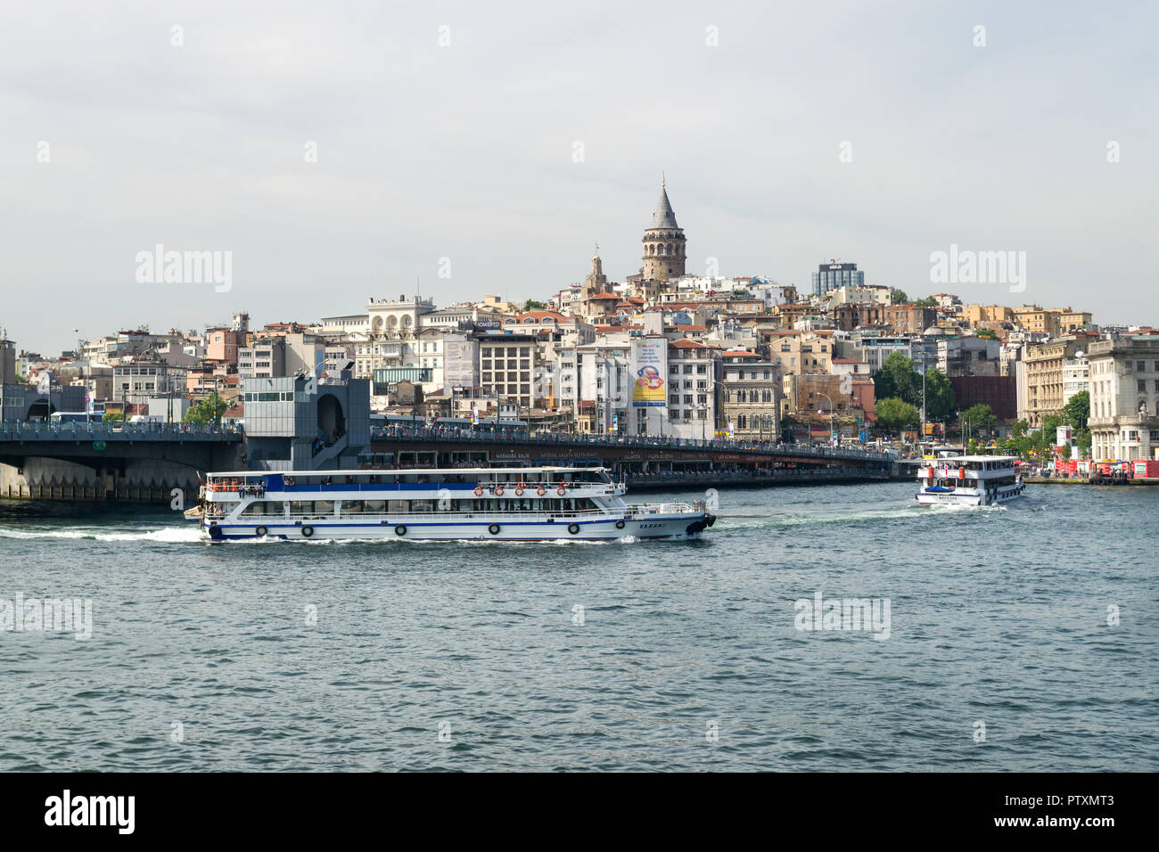 Vista verso Karakoy con il ponte Galata e Torre Galata come i traghetti navigano passato sulla lo stretto del Bosforo, Istanbul, Turchia Foto Stock
