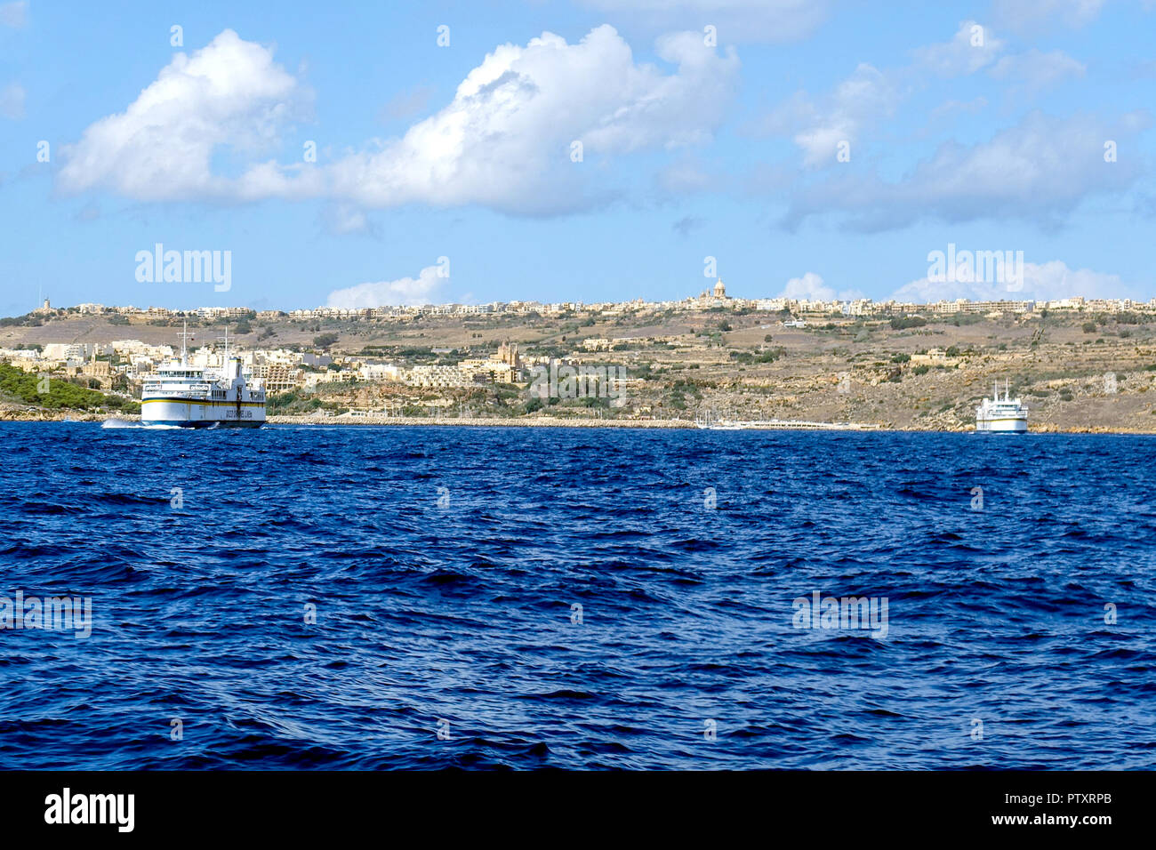 Due Gozo inter-island ferries sul passaggio tra Malta e Gozo. Gozo e MGarr porto traghetti sull orizzonte Foto Stock