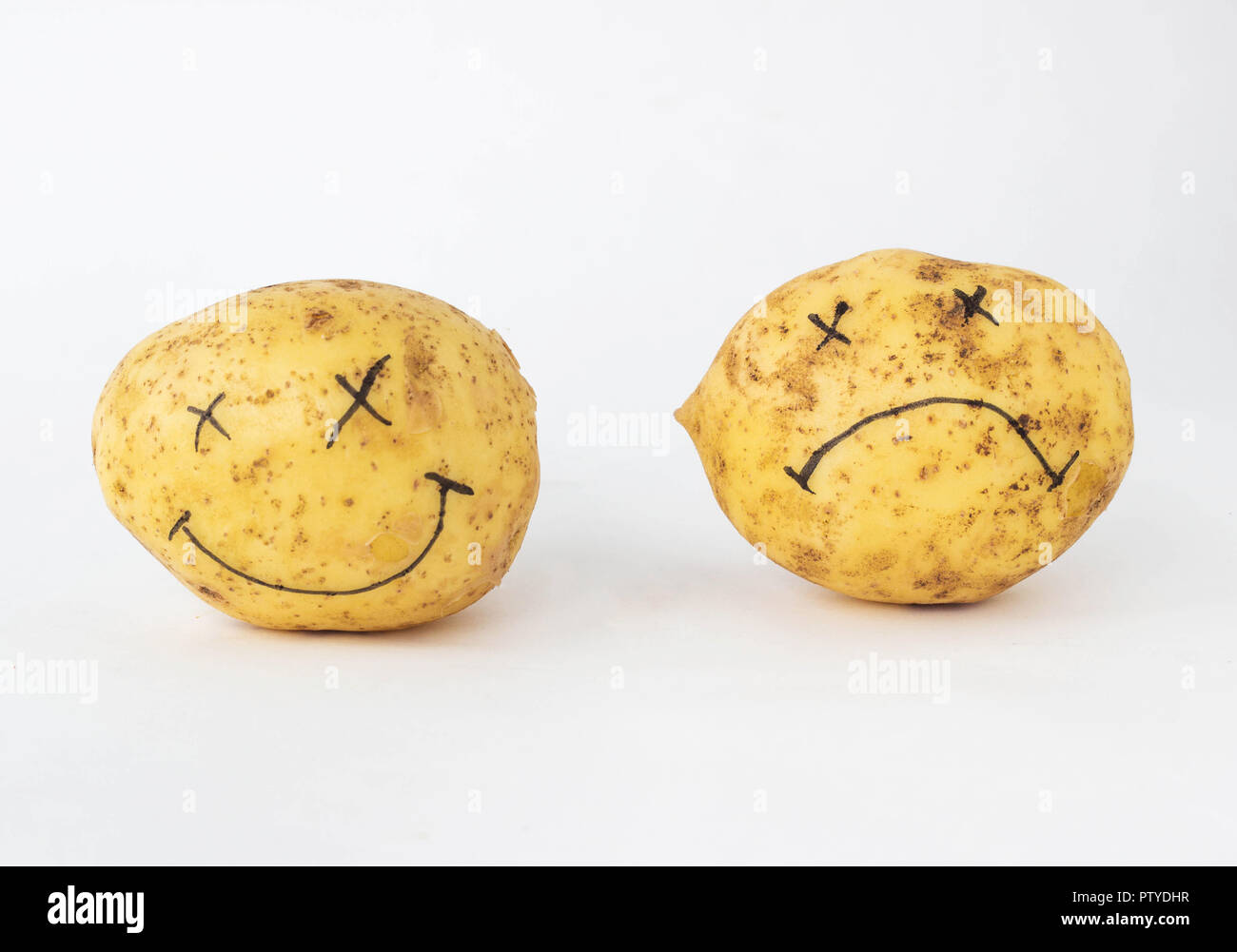 Patate su uno sfondo bianco con una cupa e contenti faccia con nessun OGM e nitrati e con nitrati, close-up, organismo geneticamente modificato, pratie Foto Stock