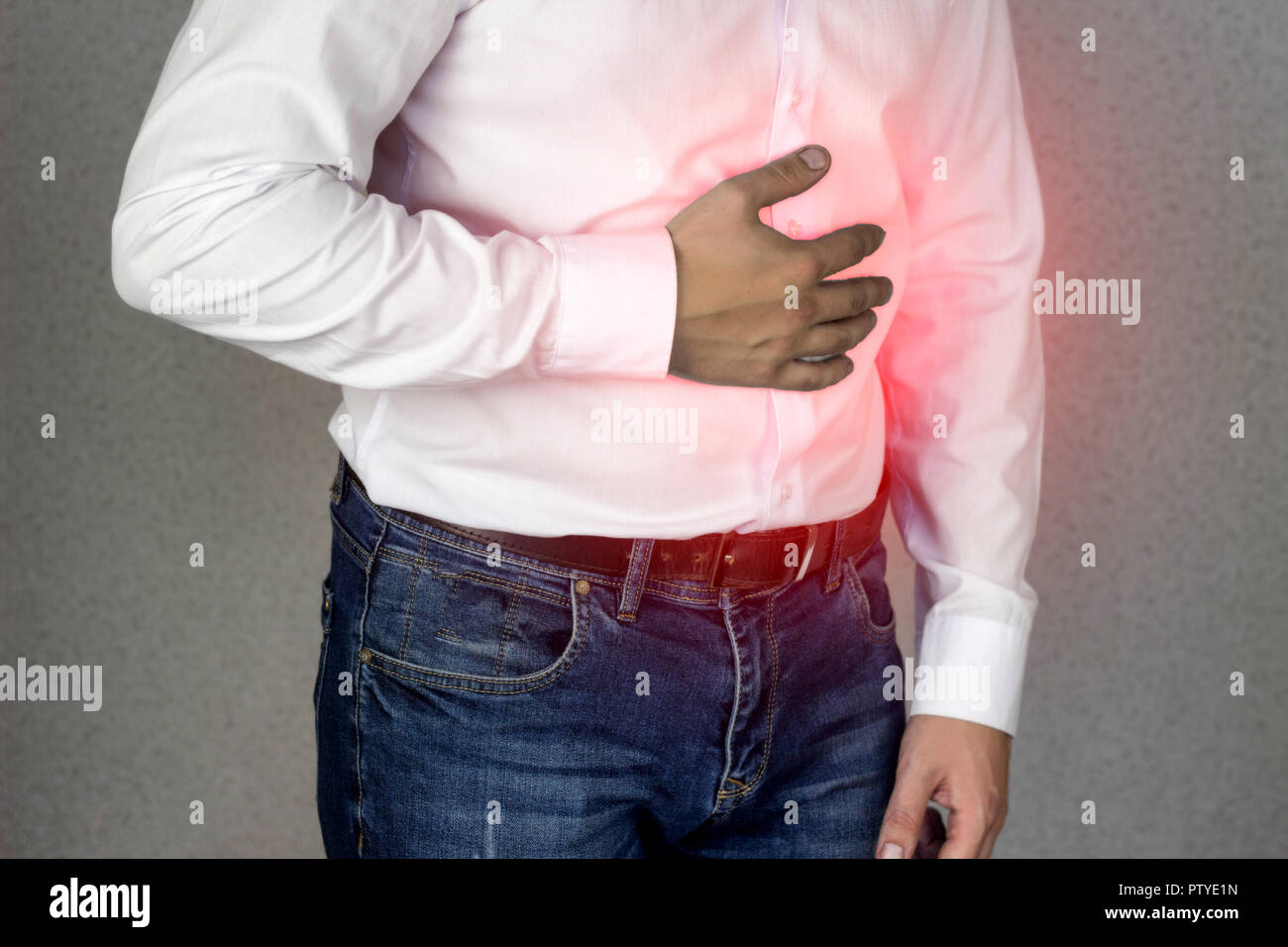 Un Uomo in camicia bianca detiene sul ventre, dolore addominale, bruciori di stomaco, close-up Foto Stock