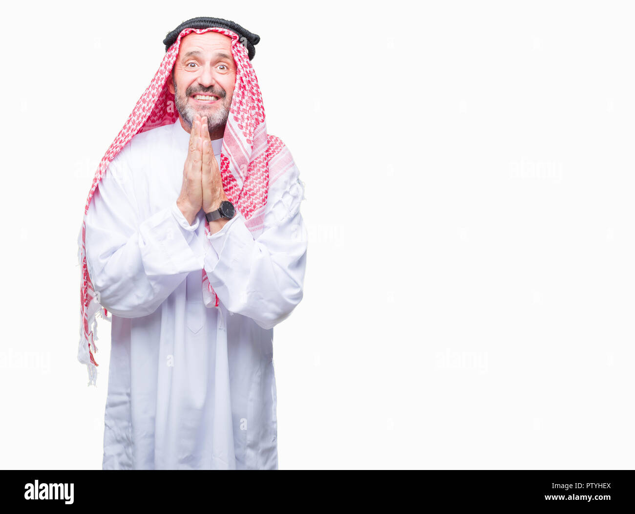 Senior uomo arabo indossando keffiyeh su sfondo isolato a pregare con le mani insieme per chiedere perdono a sorridere fiducioso. Foto Stock