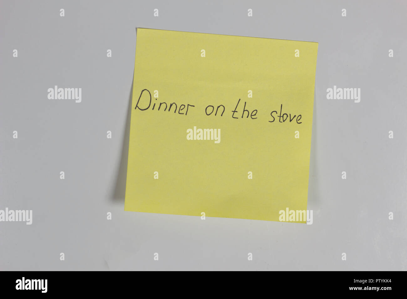 Adesivo giallo sullo sportello del frigorifero con una iscrizione a cena sulla stufa Foto Stock