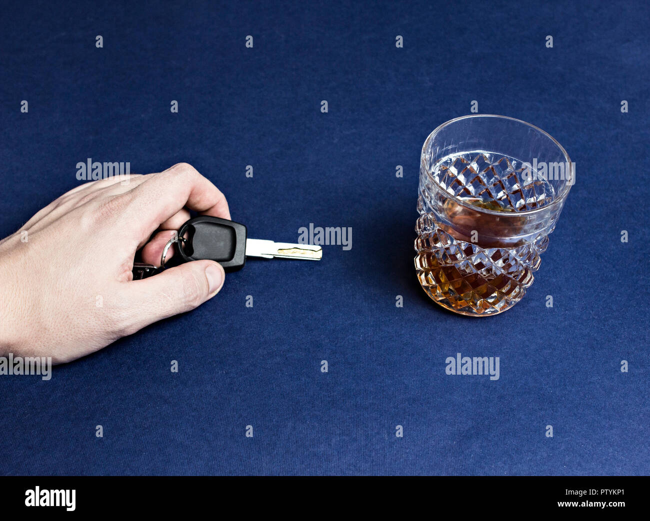 Una mano d'uomo detiene le chiavi dell'auto e alcool, close-up Foto Stock