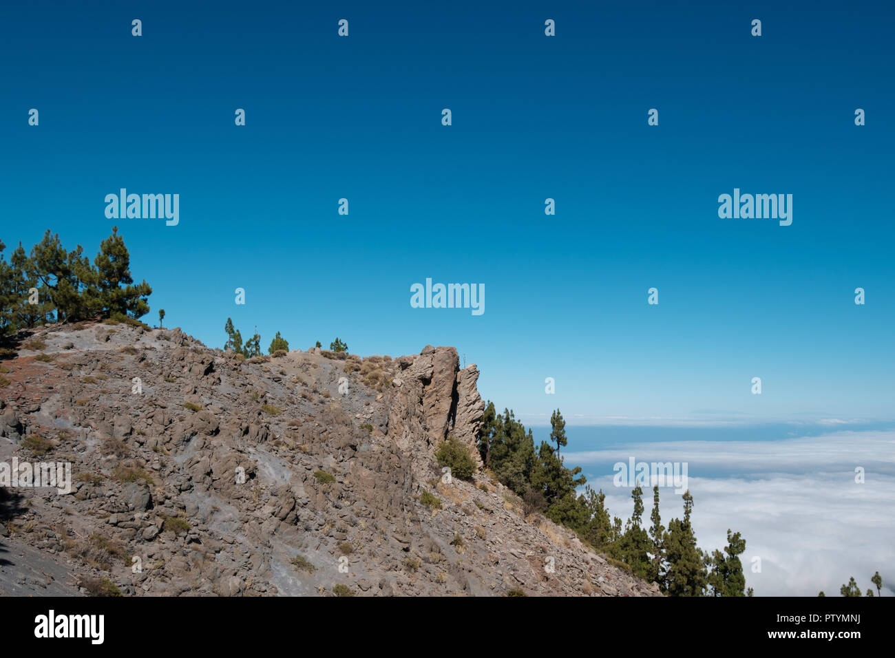 Falesia di montagna sopra le nubi con cielo azzurro sfondo Foto Stock