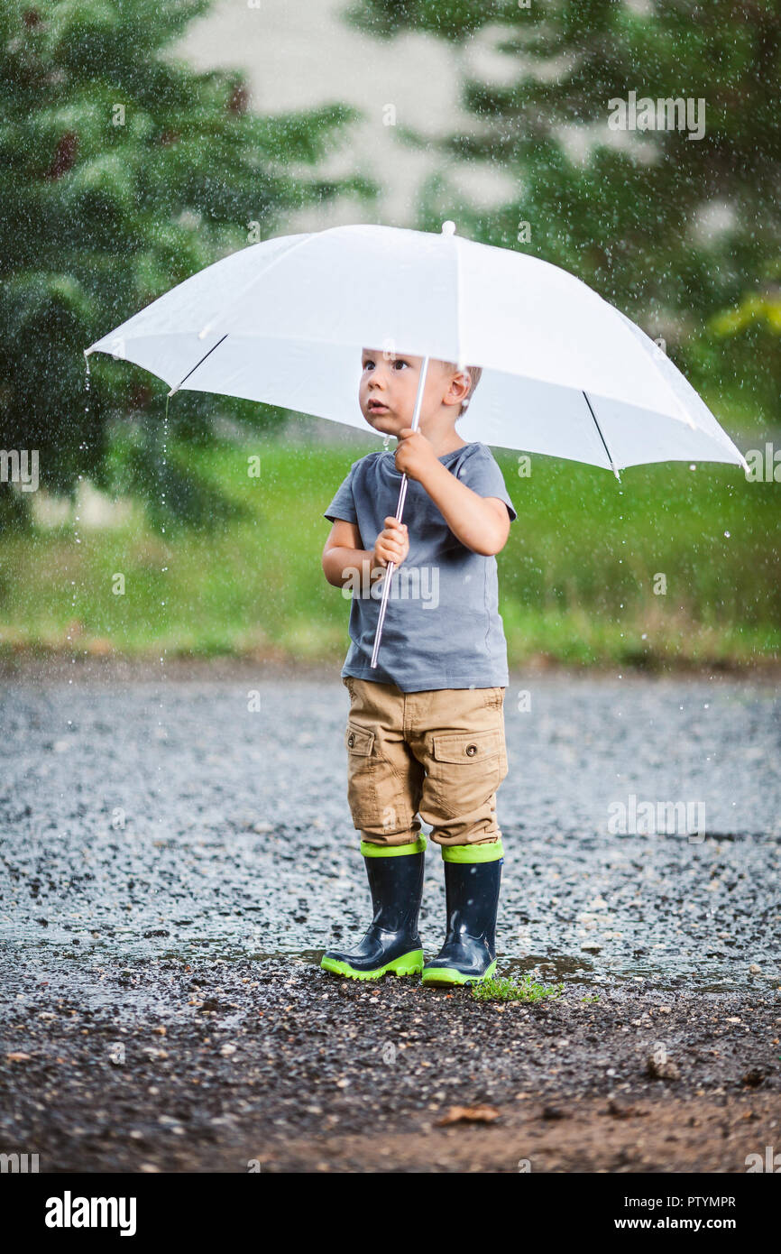 Adorabile bambino con ombrello durante una tempesta di pioggia Foto stock -  Alamy