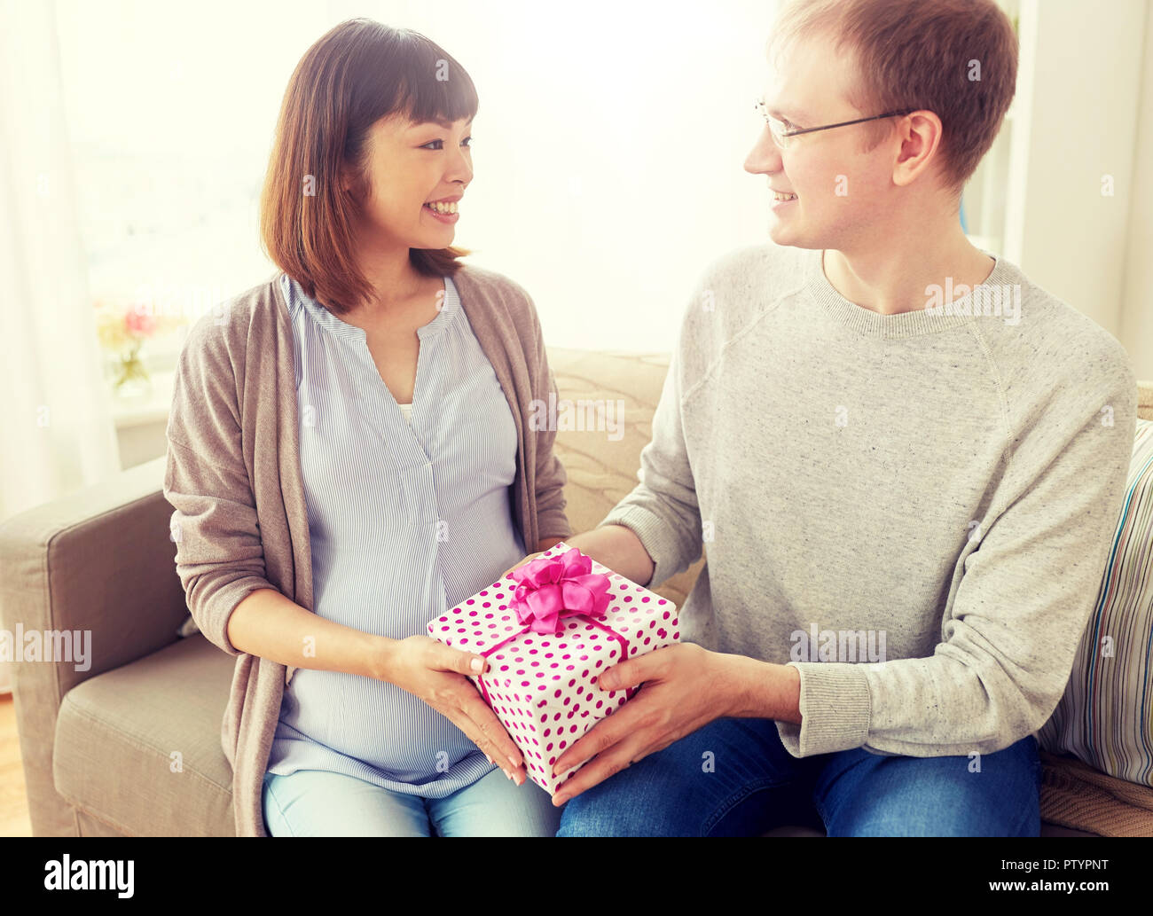 Il marito dando regalo di compleanno alla moglie incinta Foto stock - Alamy