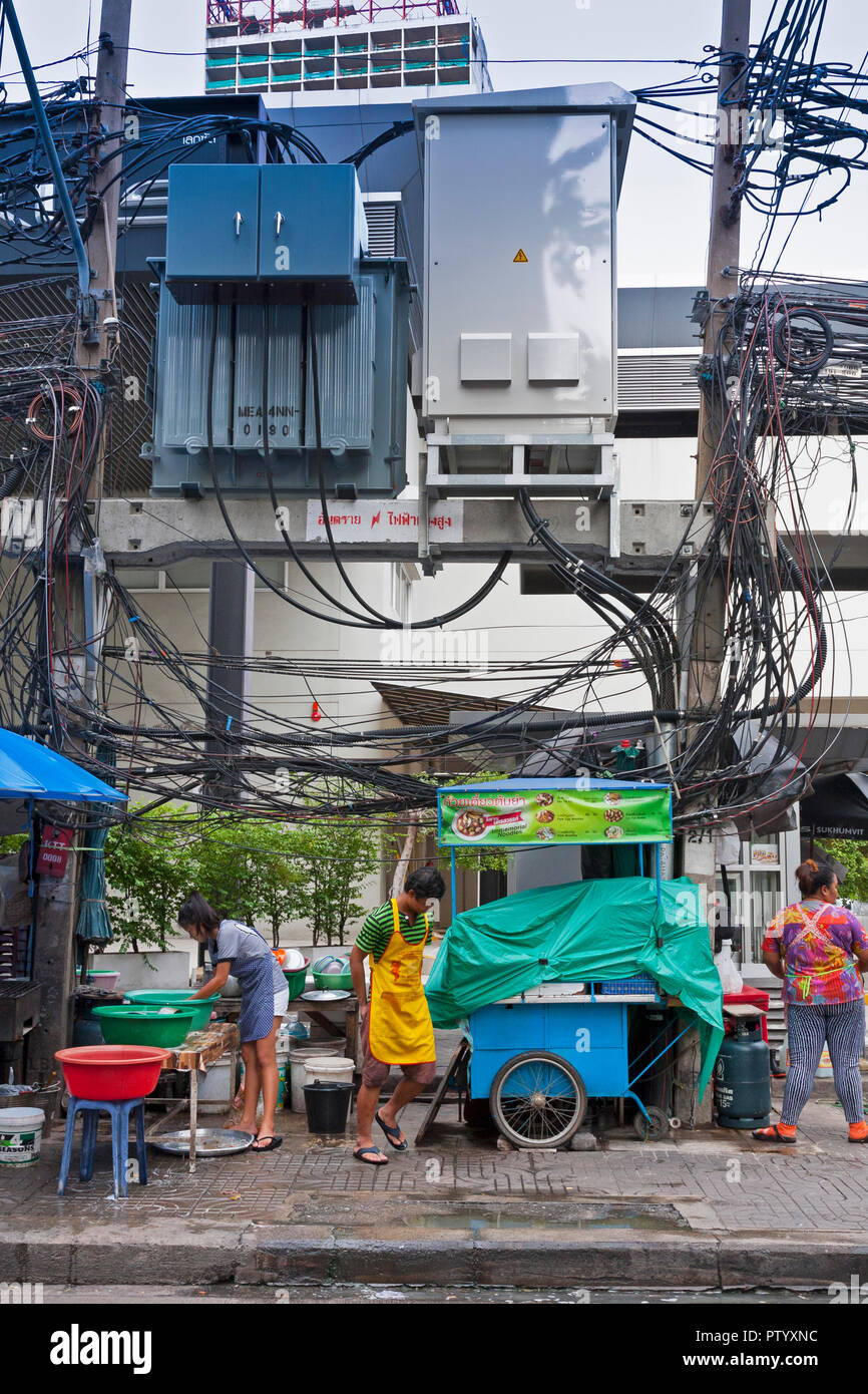 Tradizionale cibo di strada i venditori, con appeso i fili elettrici al di sopra di essi. Bangkok, Thailandia Foto Stock
