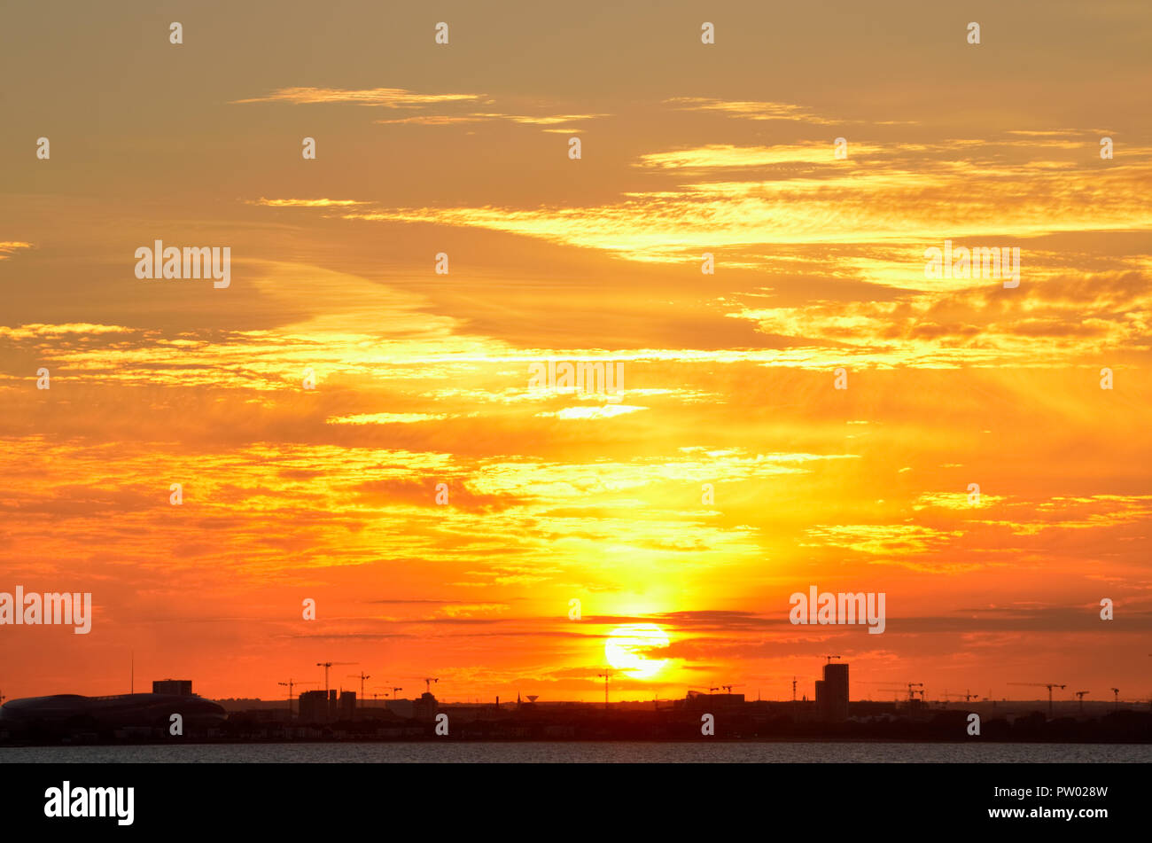Impostazione sun creando vibrante golden e sfumature di colore arancione su Dublino dello skyline della città,l'Irlanda.Fiery sky al tramonto. Foto Stock