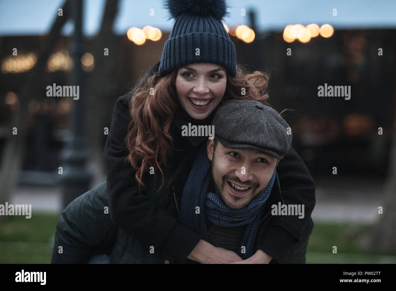Coppia giovane avendo divertimento all'aperto presso la fiera d'inverno. Indossando vestiti caldi, cappelli e sciarpe. Visitare il mercatino di natale a Vienna, Austria. Tutto è de Foto Stock