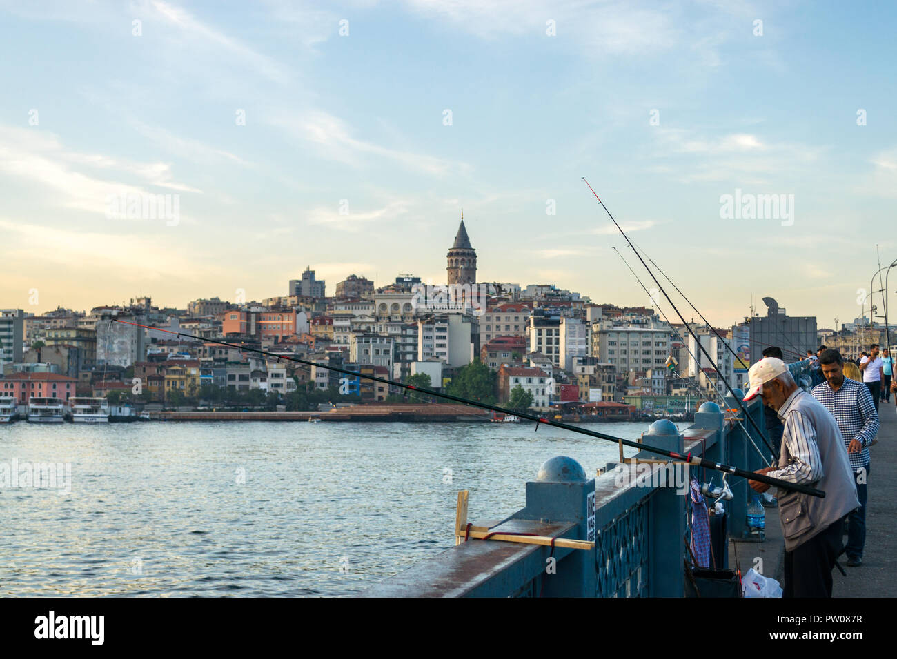 Il Ponte di Galata con la pesca dei pescatori al tramonto con Torre Galata e Karakoy distretto in background, Istanbul, Turchia Foto Stock