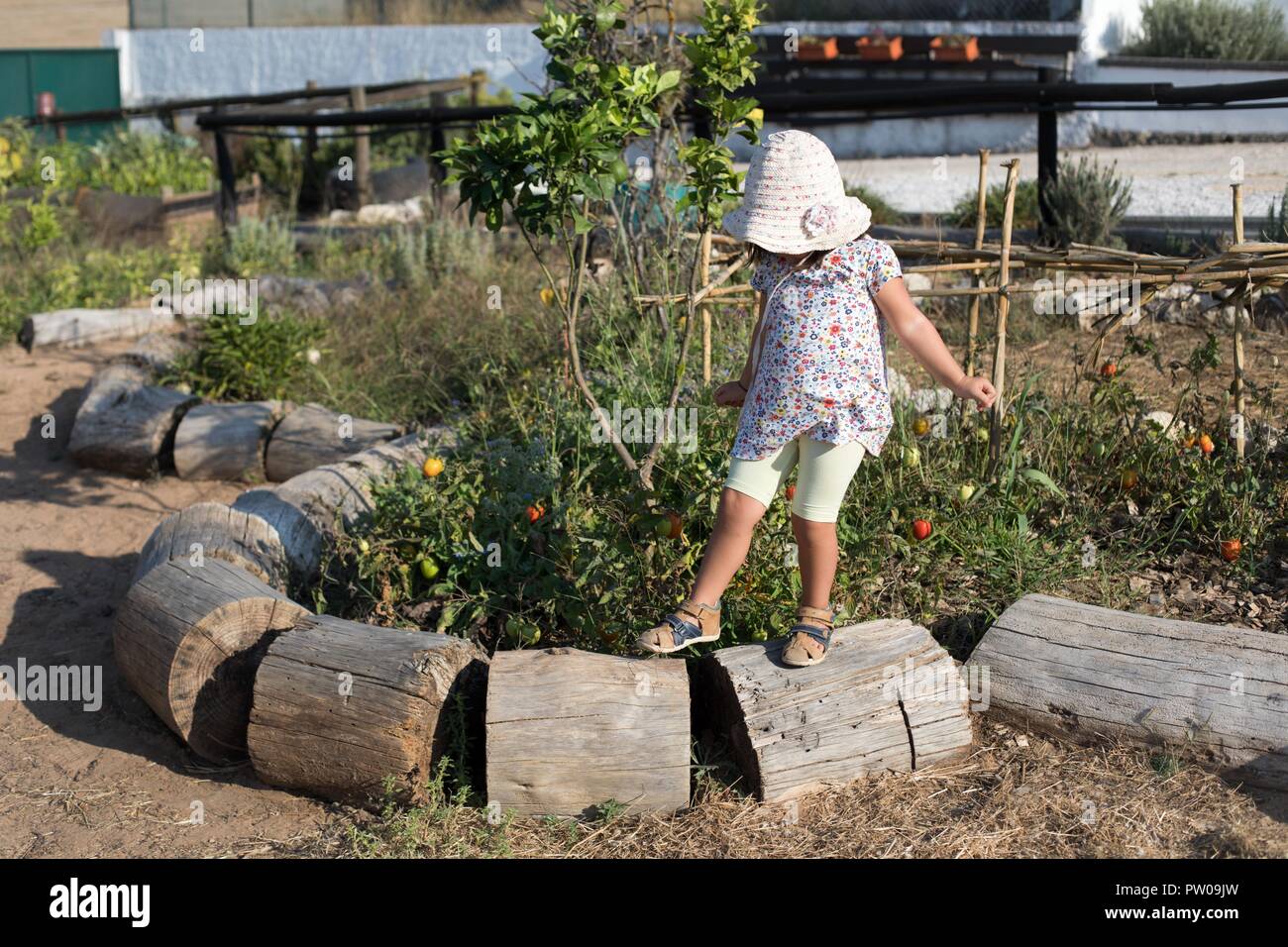 Una giovane ragazza camminare in un orto. Foto Stock