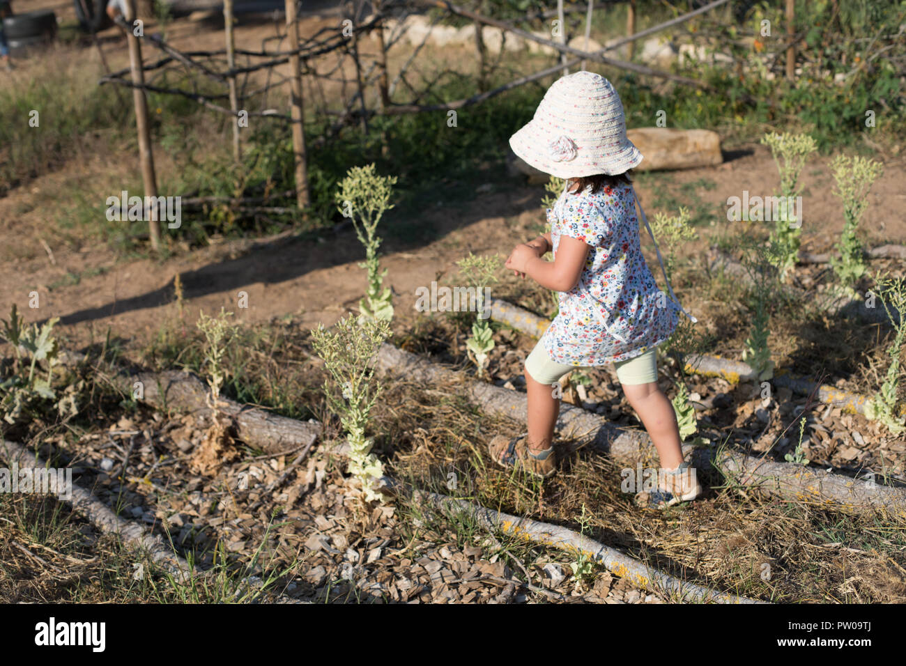 Una giovane ragazza camminare in un orto. Foto Stock