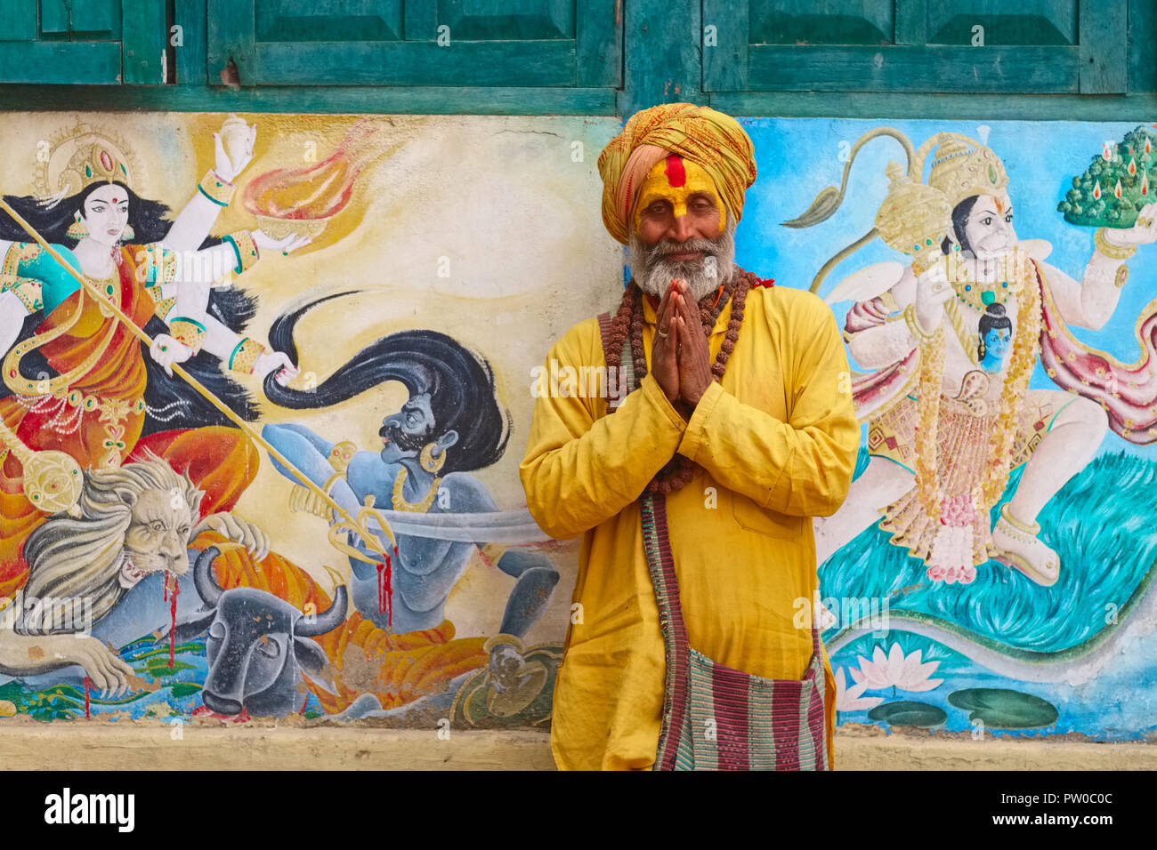 Un Sadhu o uomo santo al tempio di Pashupatinath, dal fiume Bagmati, Kathmandu, Nepal, con le mani giunte per il tradizionale saluto indù di Namaste Foto Stock