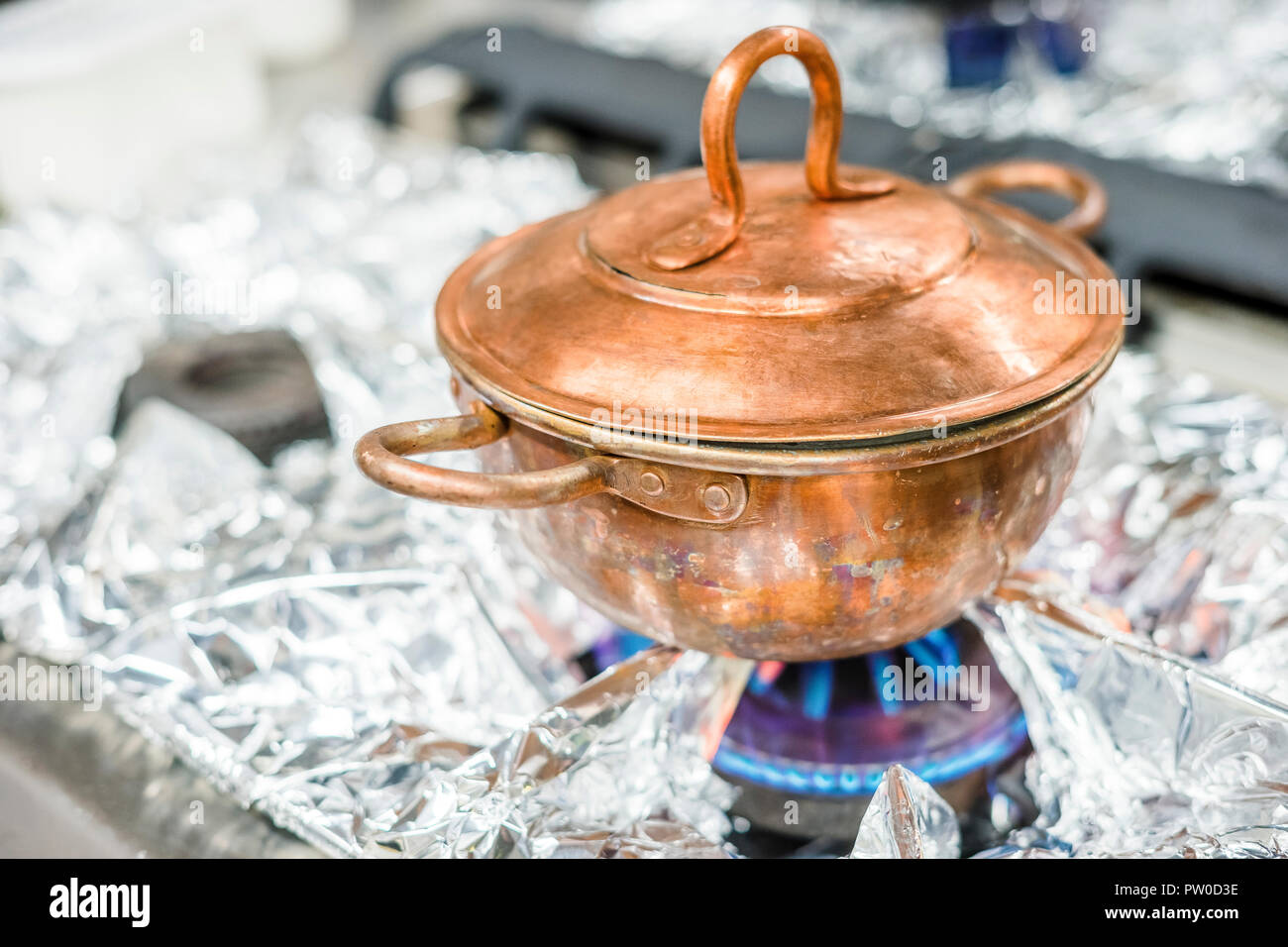 Un bronzo, vintage pentola sul fornello a gas nel ristorante di cucina Foto Stock